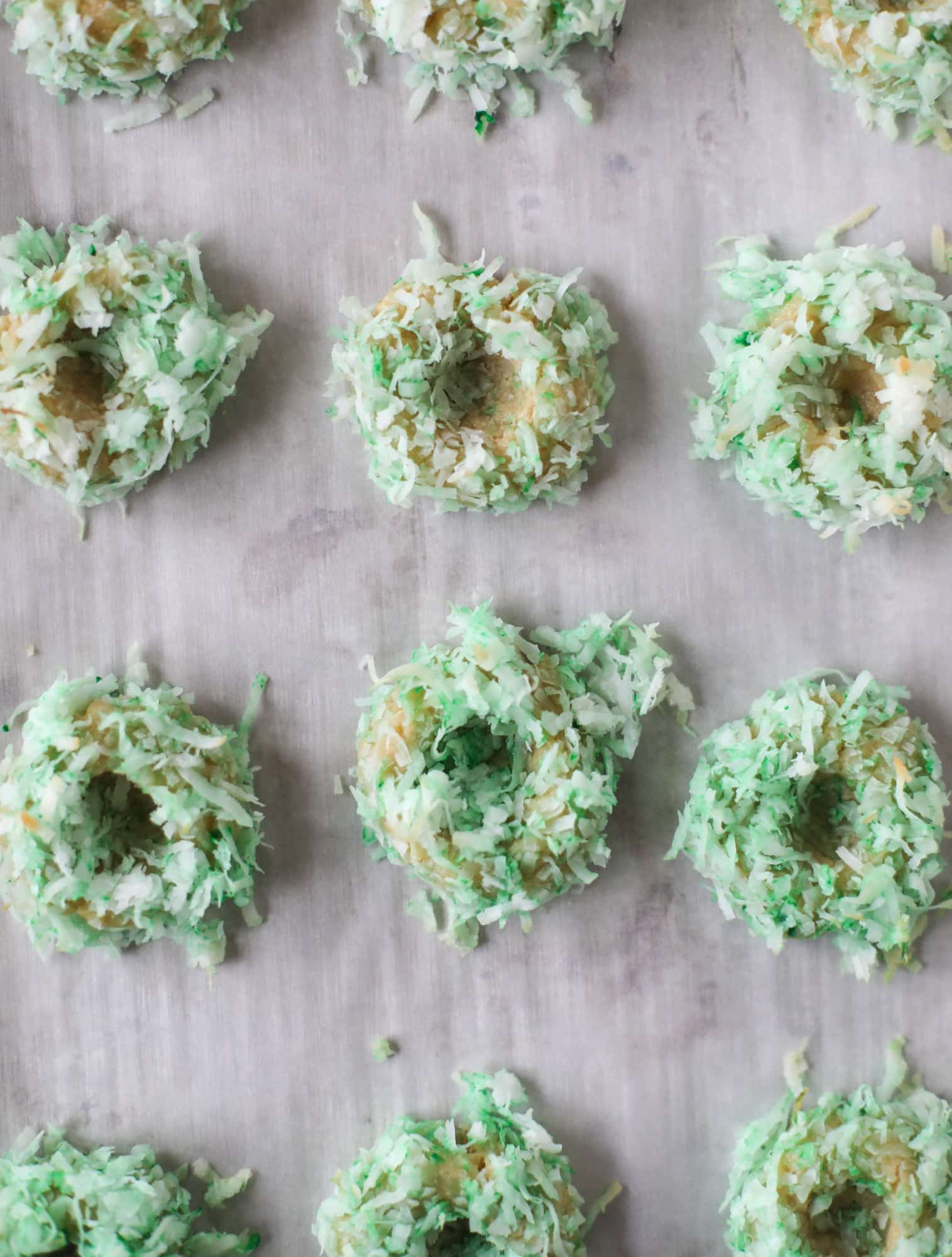 These thumbprint cookies are so perfect for the holiday season. The best butter thumbprint rolled in pink and green coconut and filled with buttercream. So festive! I personally think they look like Grinch cookies - kids love them! I howsweeteats.com #thumbprint #cookies