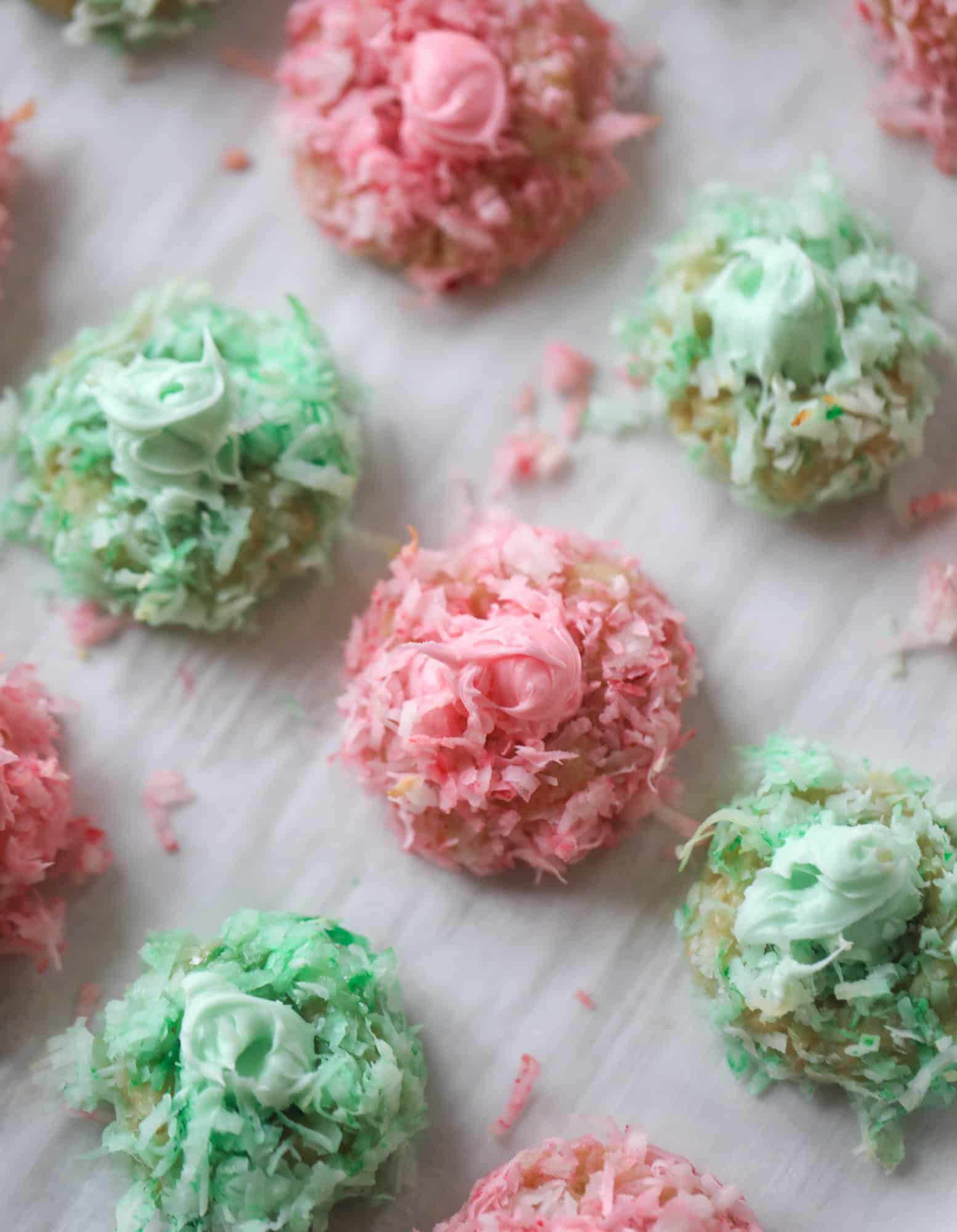 These thumbprint cookies are so perfect for the holiday season. The best butter thumbprint rolled in pink and green coconut and filled with buttercream. So festive! I personally think they look like Grinch cookies - kids love them! I howsweeteats.com #thumbprint #cookies