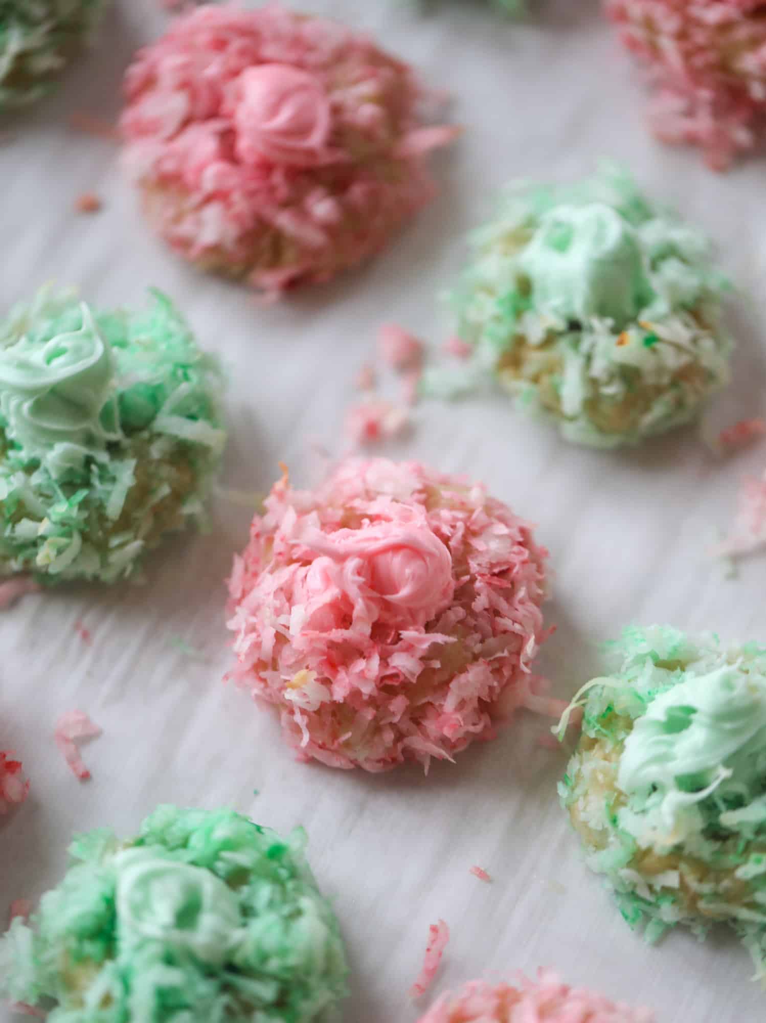 These thumbprint cookies are so perfect for the holiday season. The best butter thumbprint rolled in pink and green coconut and filled with buttercream. So festive! I personally think they look like Grinch cookies - kids love them! I howsweeteats.com #thumbprint #cookies
