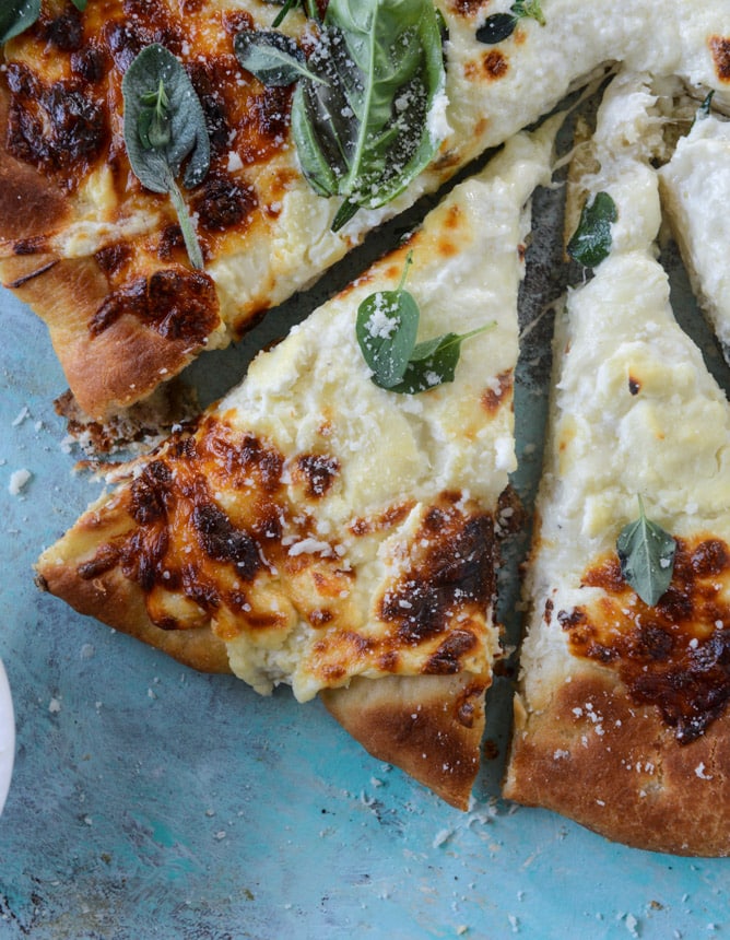 white pizza with garlic sauce and garden herbs I howsweeteats.com