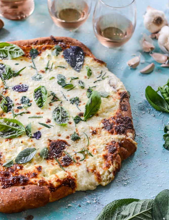 white pizza with garlic sauce and garden herbs I howsweeteats.com