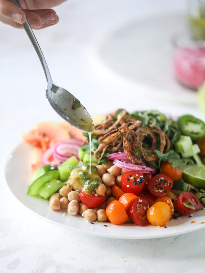 This spicy rainbow salad is chock full of gorgeous, fresh produces, chickpeas, plantains and herbs for one beautiful sight in a bowl. The rainbow salad is satisfying, filling, delicious with a touch of sweet and slightly spicy - everything you want in a meal! I howsweeteats.com #spicy #rainbow #salad 