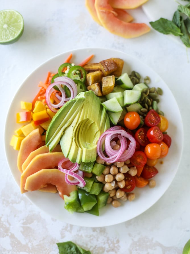 This spicy rainbow salad is chock full of gorgeous, fresh produces, chickpeas, plantains and herbs for one beautiful sight in a bowl. The rainbow salad is satisfying, filling, delicious with a touch of sweet and slightly spicy - everything you want in a meal! I howsweeteats.com #spicy #rainbow #salad 