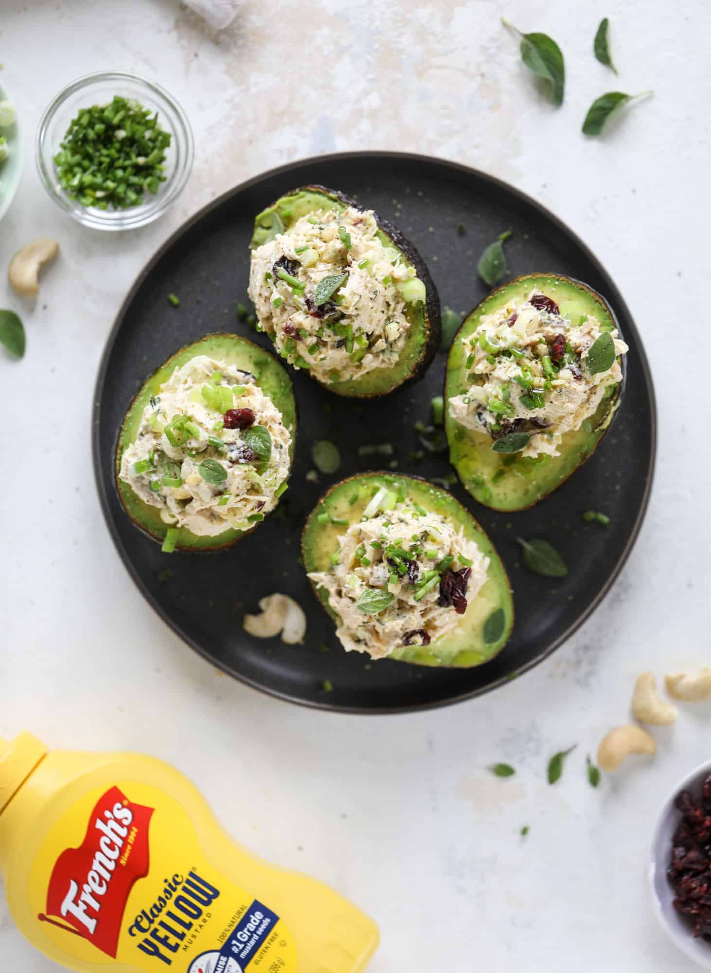 These smoky chicken salad stuffed avocados are lunchtime gold! They are super easy to throw together, satisfying and pretty darn great for you. Made with greek yogurt, some tangy mustard and dried cherries for sweetness, they are delish! I howsweeteats.com #chicken #salad #stuffed #avocados #greekyogurt