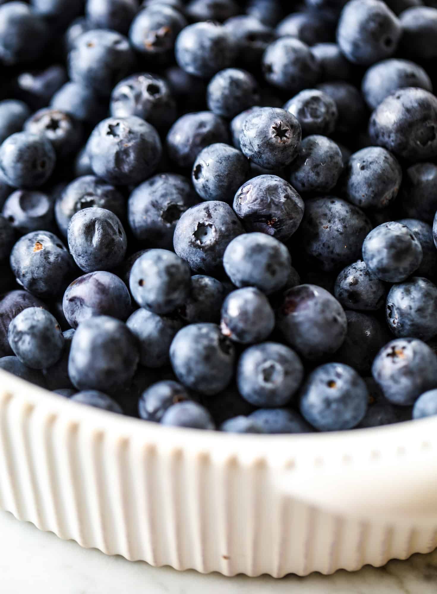 This blueberry crisp is warm and bursting with sweet and juicy fruit. It's topped with a quinoa oatmeal brown sugar topping and is the perfect dessert for summer. Served warm and topped with vanilla ice cream, it's just divine! I howsweeteats.com #blueberry #crisp #quinoa #oats #dessert #fruit 