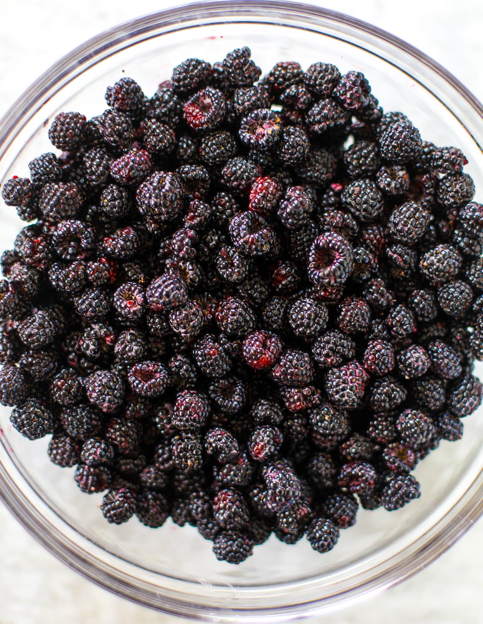 This black raspberry cobbler is a summer dream come true! The bursting black raspberries are rich and sweet, then add in a touch of lavender for incredible flavor and you're all set. The cobbler cake topping is perfect for vanilla ice cream. Win! I howsweeteats.com #black #raspberry #cobbler #lavender #summer #desserts #icecream