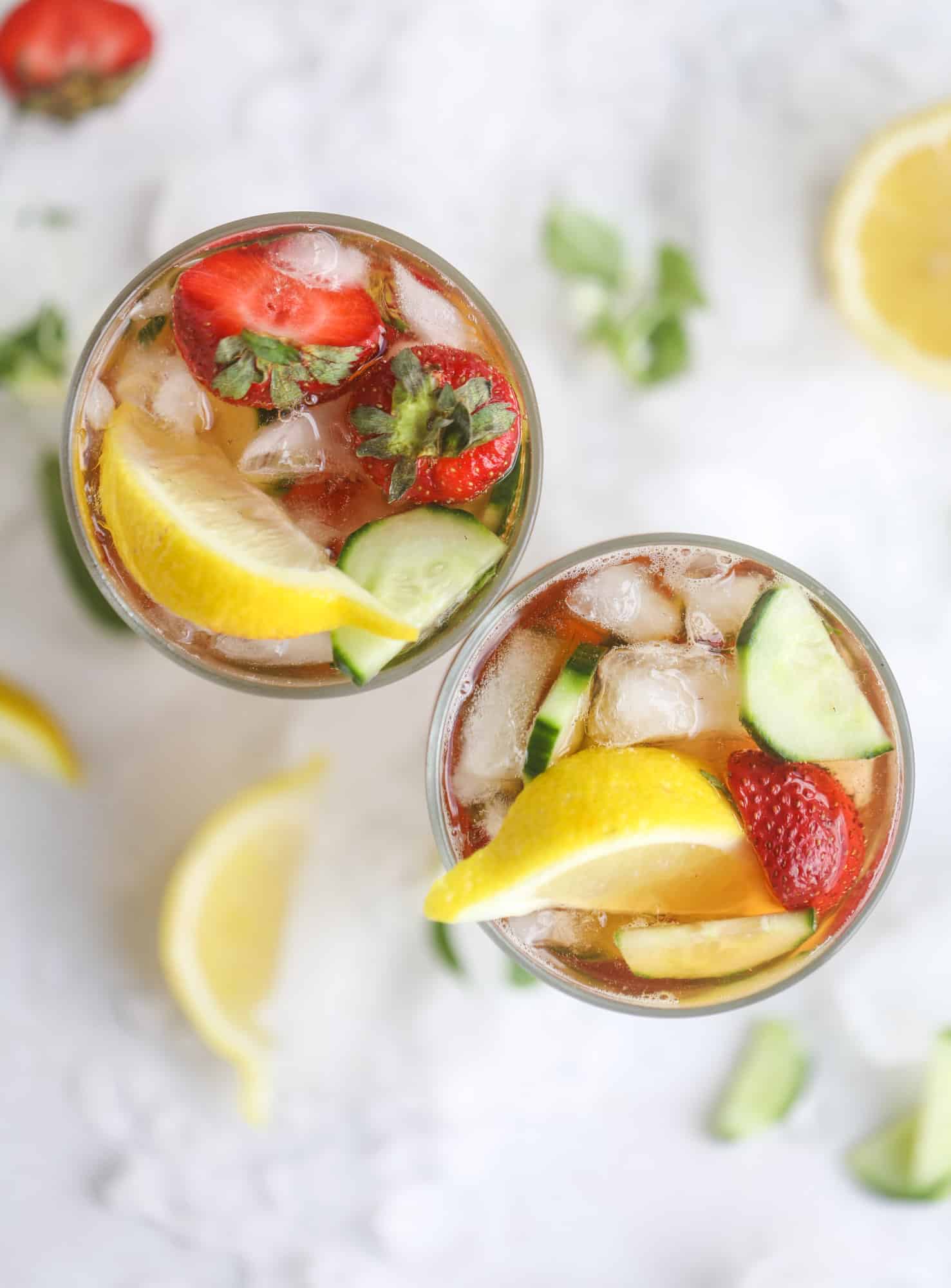 I love a delicious Pimm's Cup in the heart of summer! This was is topped with sparkling rosé wine and filled with strawberries, cucumbers and lemon wedges. It's super refreshing and perfect on hot hot days! I howsweeteats.com #pimms #cup #recipe #cocktails #rosé #sparkling #summer