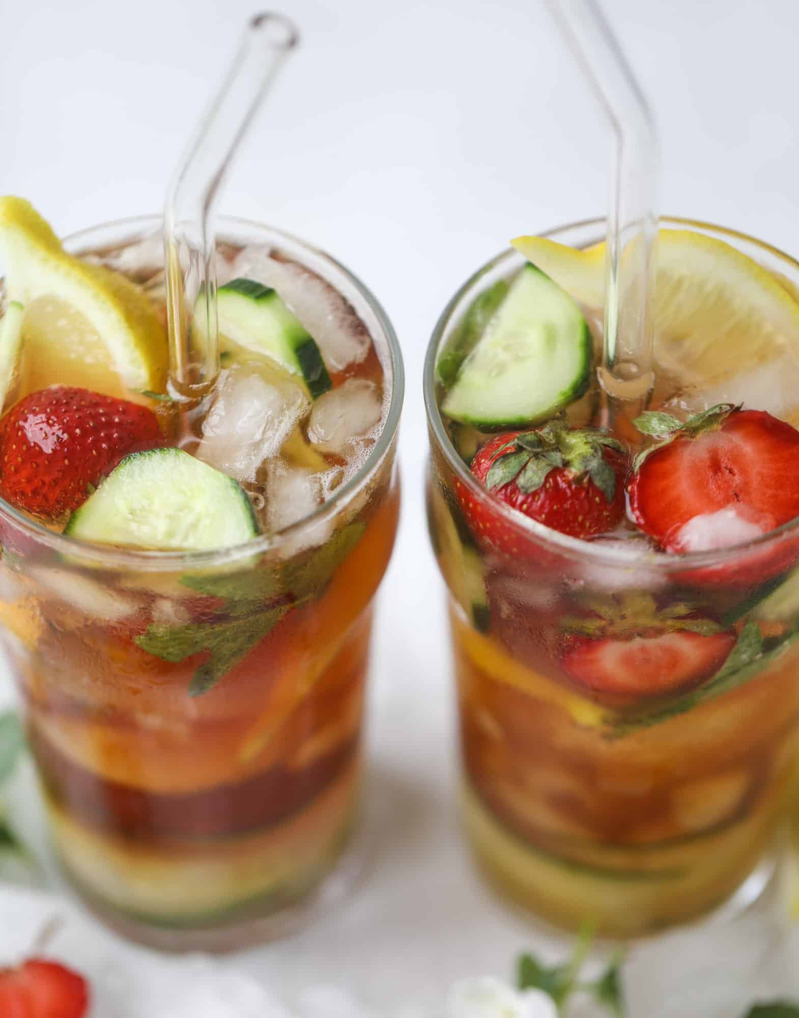 I love a delicious Pimm's Cup in the heart of summer! This was is topped with sparkling rosé wine and filled with strawberries, cucumbers and lemon wedges. It's super refreshing and perfect on hot hot days! I howsweeteats.com #pimms #cup #recipe #cocktails #rosé #sparkling #summer