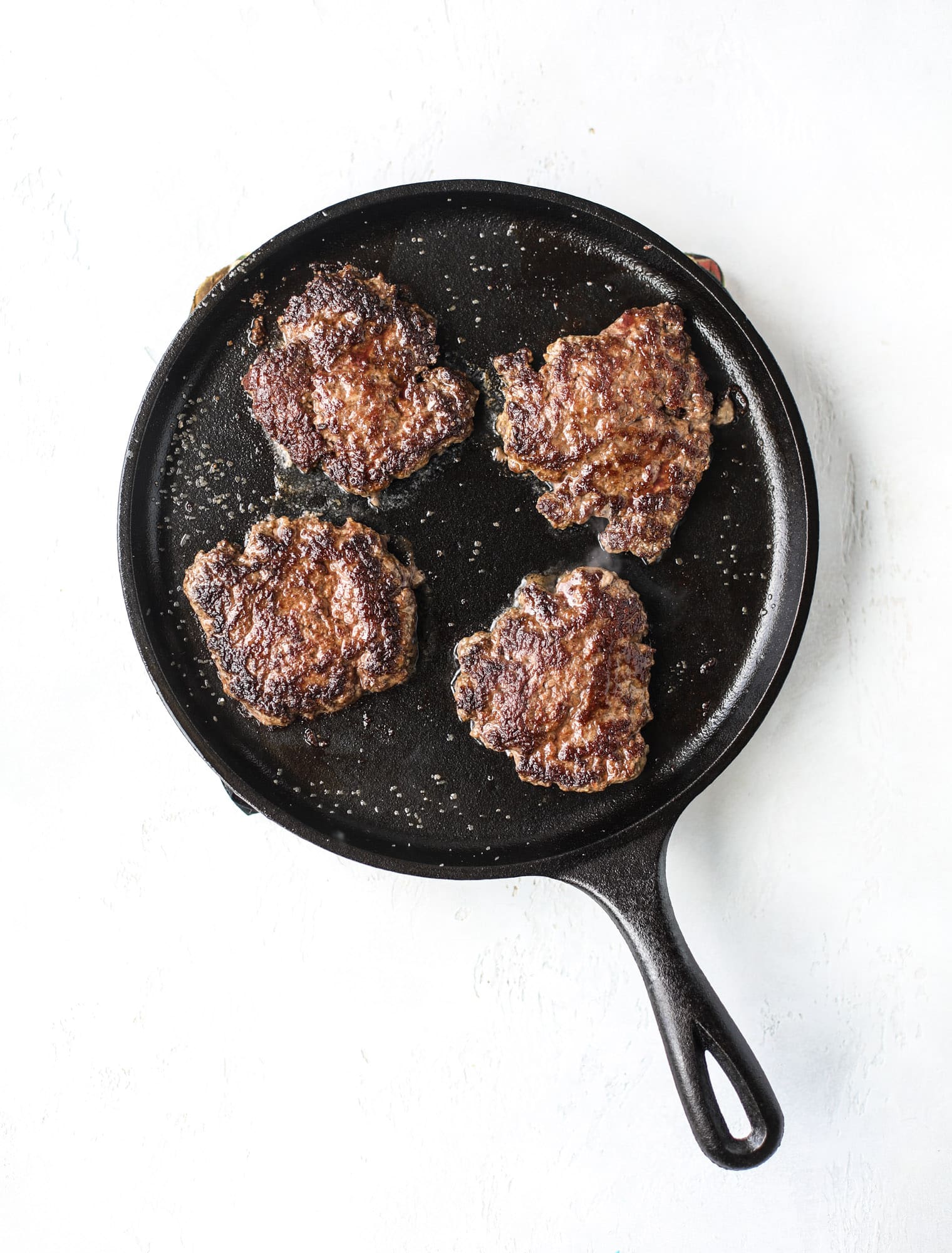 These smash burgers are to die for! All you need are a few ingredients and 30 minutes to make these smash burgers happen. Topped with melty smoked gouda and topped with a creamy, tangy house sauce, these are the best burgers ever! I howsweeteats.com #smash #burgers #smoked #gouda #special #sauce