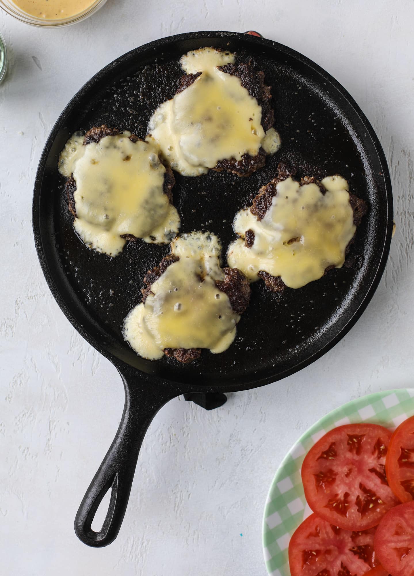 These smash burgers are to die for! All you need are a few ingredients and 30 minutes to make these smash burgers happen. Topped with melty smoked gouda and topped with a creamy, tangy house sauce, these are the best burgers ever! I howsweeteats.com #smash #burgers #smoked #gouda #special #sauce