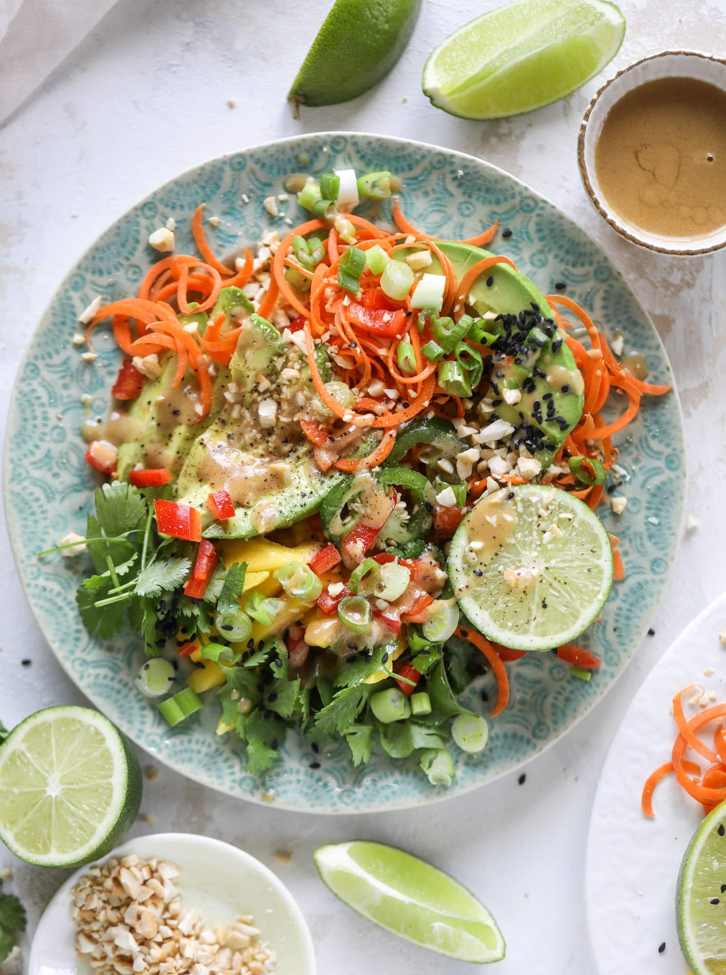 This thai avocado salad is loaded with mango, red pepper, carrots, green onions and drizzled with a peanut butter vinaigrette. It's an amazing side salad or a fabulous dinner salad - add on chickpeas or shrimp or chicken if you wish! I howsweeteats.com #thai #avocado #salad #peanutbutter #mango #lime