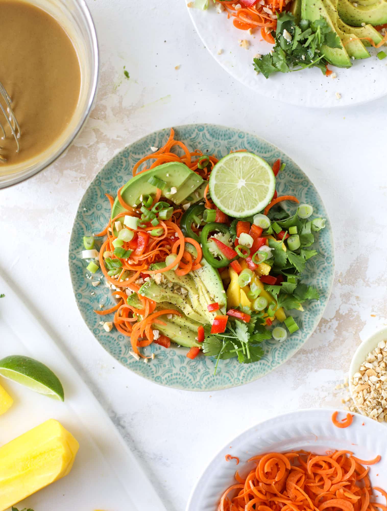 This thai avocado salad is loaded with mango, red pepper, carrots, green onions and drizzled with a peanut butter vinaigrette. It's an amazing side salad or a fabulous dinner salad - add on chickpeas or shrimp or chicken if you wish! I howsweeteats.com #thai #avocado #salad #peanutbutter #mango #lime