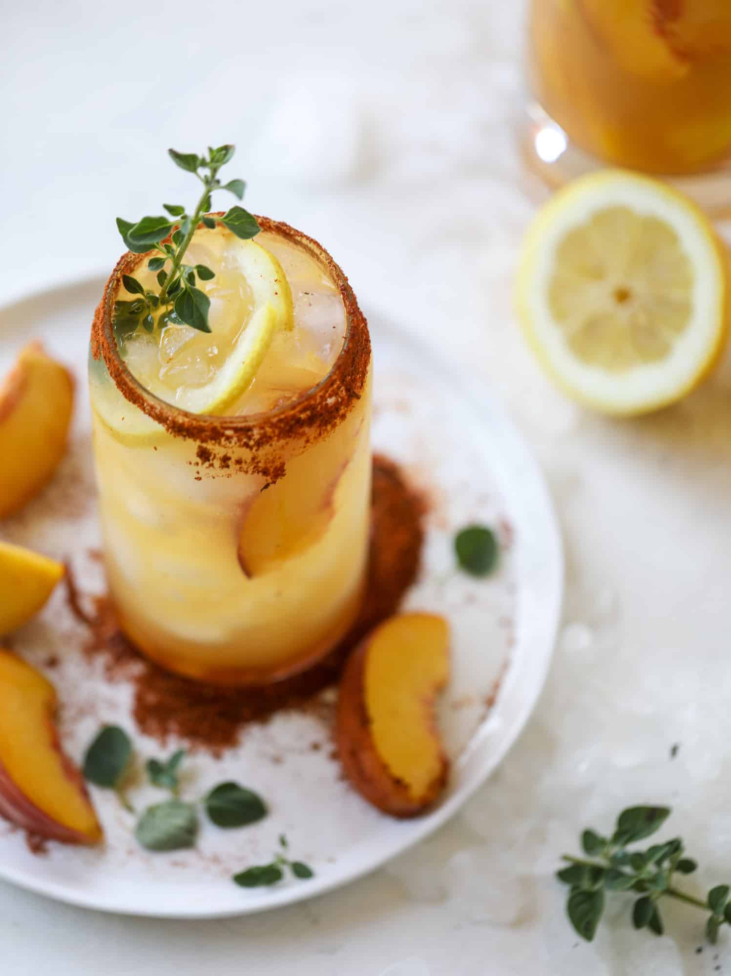 This peach lemonade is super refreshing and a bit spicy for a hot and sunny summer day. It's sweet and fresh and the rim is dipped in a cajun seasoning, bringing the best bite of heat to this perfect summer drink. So fresh! I howsweeteats.com #peach #lemonade #cajun #summer #mocktail #lemon #drink