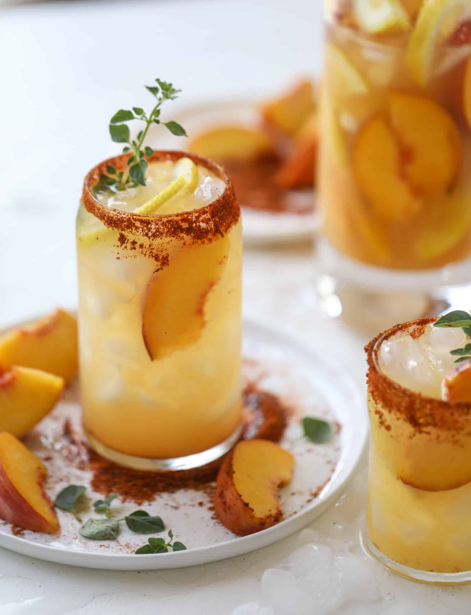 This peach lemonade is super refreshing and a bit spicy for a hot and sunny summer day. It's sweet and fresh and the rim is dipped in a cajun seasoning, bringing the best bite of heat to this perfect summer drink. So fresh! I howsweeteats.com #peach #lemonade #cajun #summer #mocktail #lemon #drink