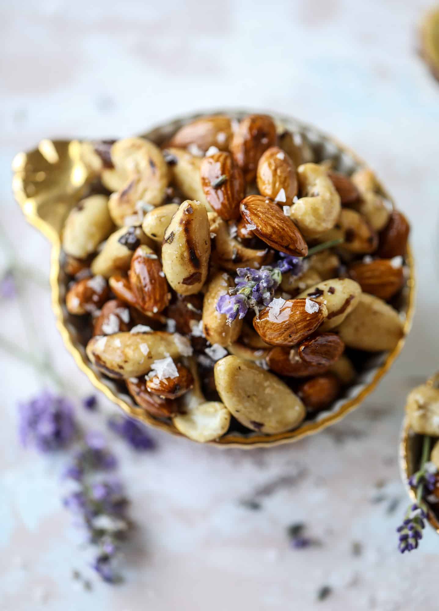 These salted honey lavender nuts are the best snack to make for when you're on the go or when you need a perfect appetizer for your dinner party. Roasted, sweet and salty with a hint of lavender makes these irresistible! I howsweeteats.com #honey #lavender #nuts #salted #almonds #cashews #snacks #appetizers