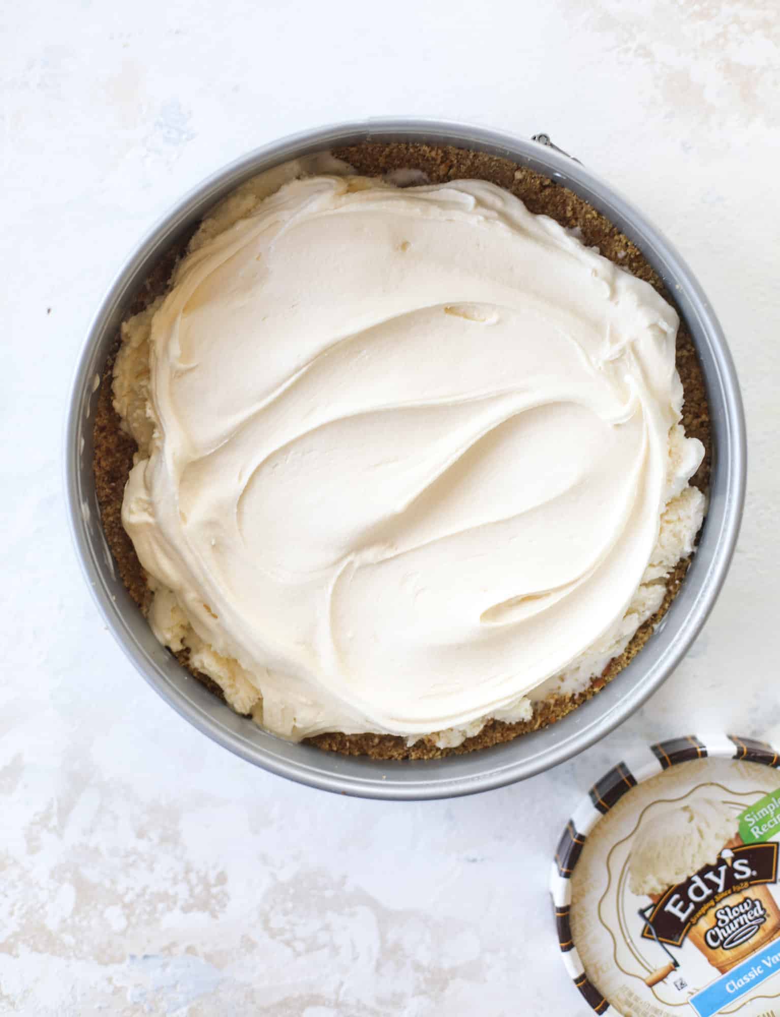 This peanut butter fudge ice cream cake is absolutely insane and perfect for summer! A sweet and savory pretzel crust, vanilla ice cream, homemade hot fudge and a peanut butter whipped cream layer take it to the next LEVEL. Delicious! I howsweeteats.com #icecream #cake #peanutbutter #chocolate #pretzel