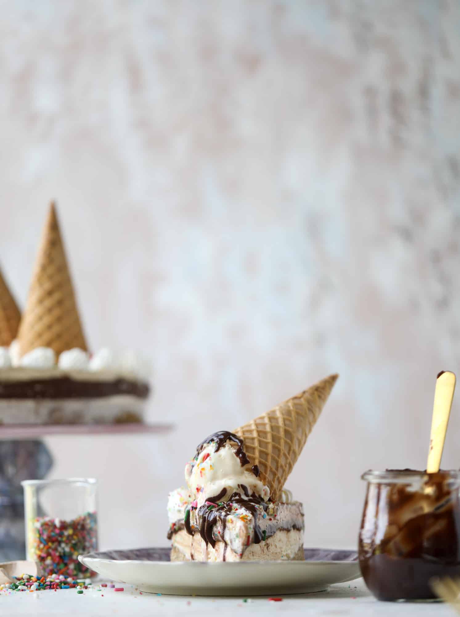 This peanut butter fudge ice cream cake is absolutely insane and perfect for summer! A sweet and savory pretzel crust, vanilla ice cream, homemade hot fudge and a peanut butter whipped cream layer take it to the next LEVEL. Delicious! I howsweeteats.com #icecream #cake #peanutbutter #chocolate #pretzel