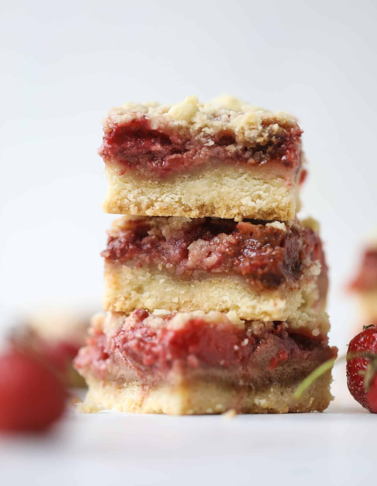 These strawberry cobbler bars are super delicious and perfect for a crowd! Made with juicy fresh strawberries, they start with a shortbread crust and end with a crumbly topping with a warm and delicious fruity filling. Huge hit! I howsweeteats.com #strawberry #cobbler #bars