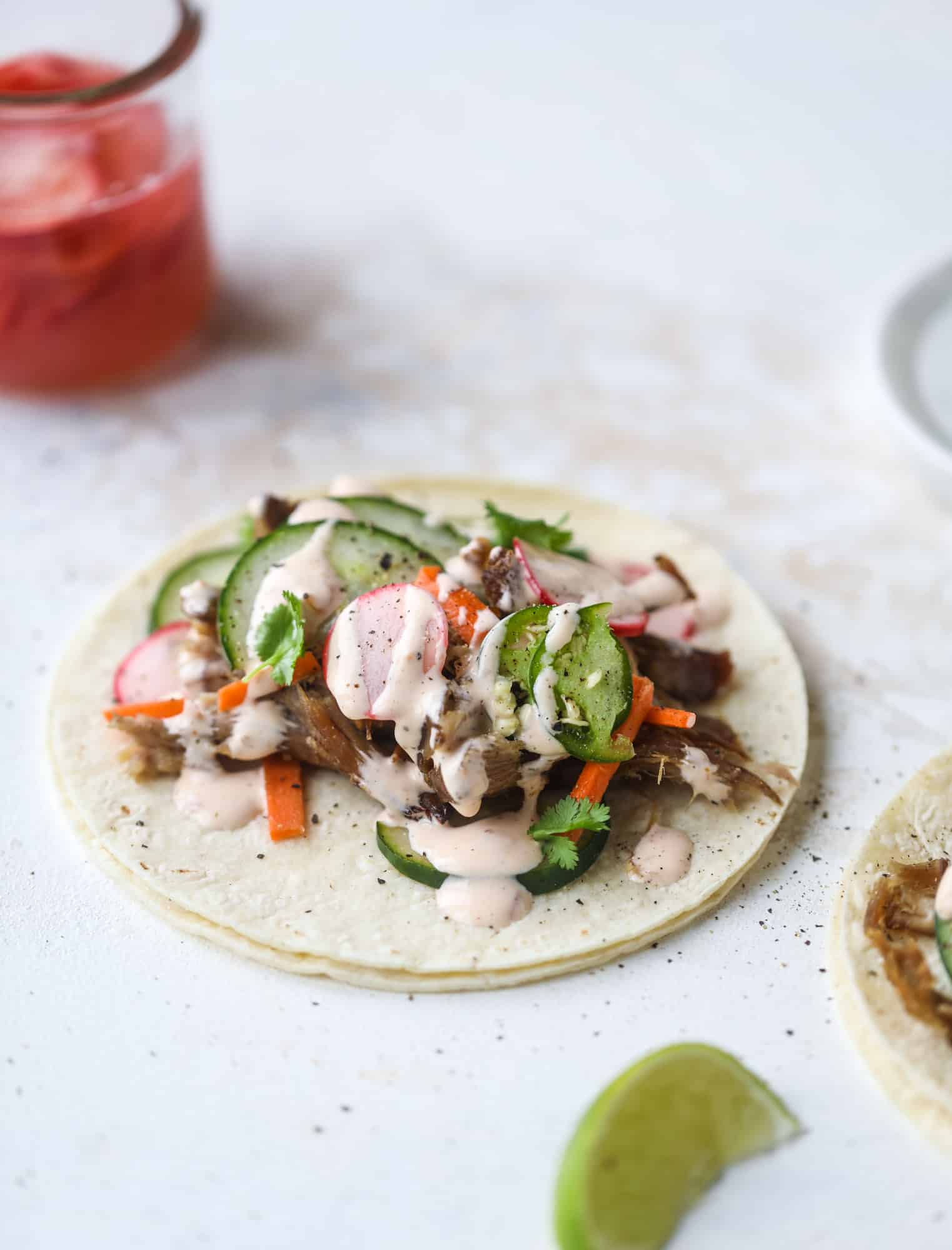 These bahn mi tacos are the perfect twist on the classic sandwich! Juicy pulled pork, pickled veggies, a tangy crema and loads of flavor. Bahn mi tacos are a delish weeknight meal or also work great if you have pork leftovers! I howsweeteats.com #bahn #mi #tacos #pork #dinner