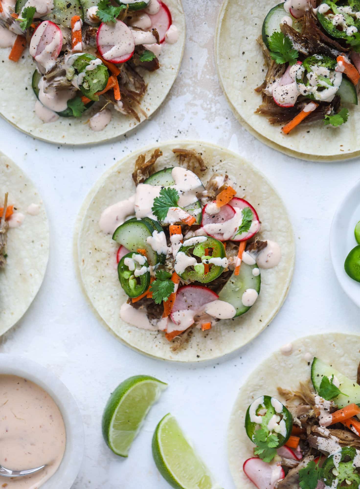 These bahn mi tacos are the perfect twist on the classic sandwich! Juicy pulled pork, pickled veggies, a tangy crema and loads of flavor. Bahn mi tacos are a delish weeknight meal or also work great if you have pork leftovers! I howsweeteats.com #bahn #mi #tacos #pork #dinner