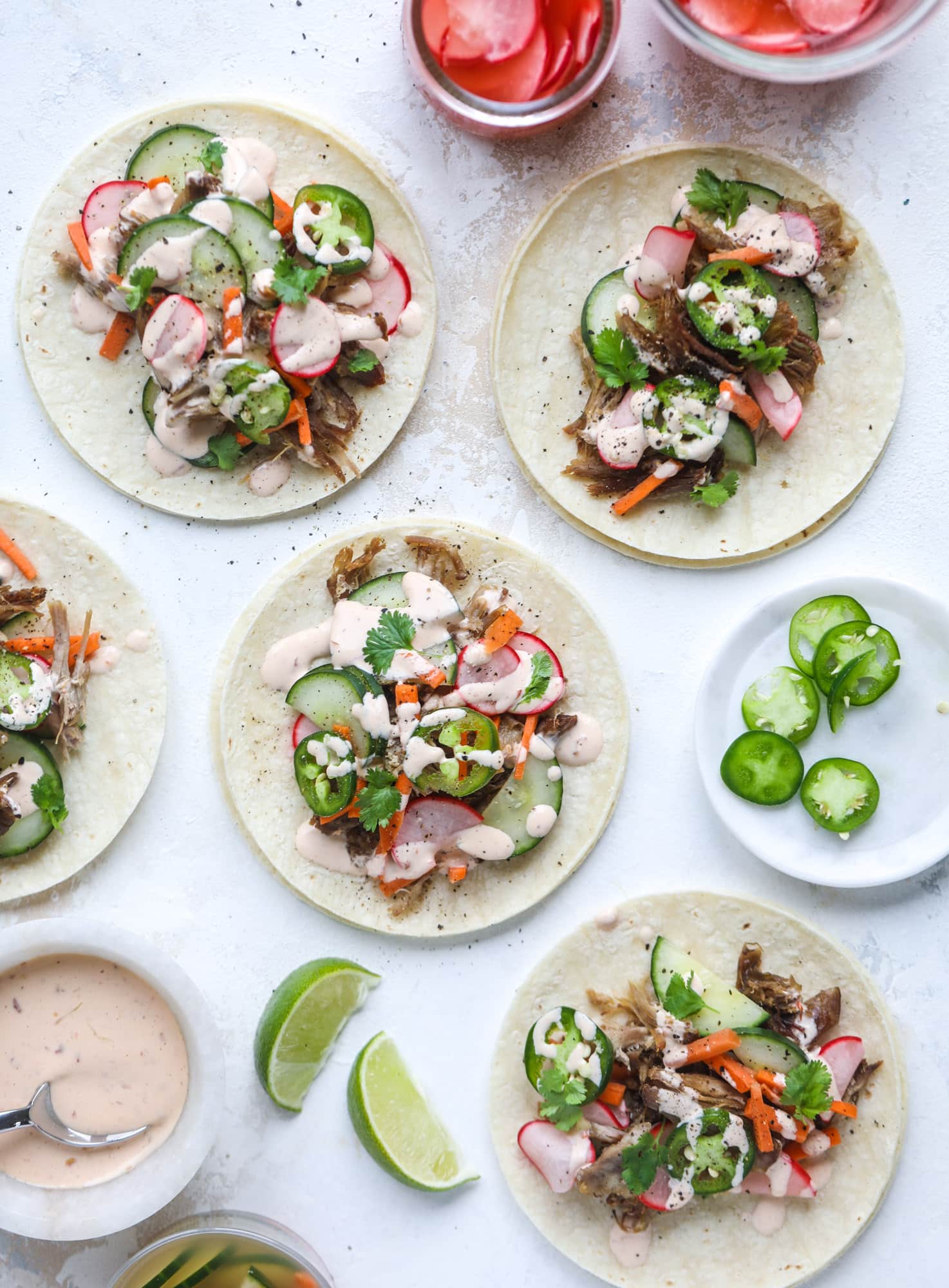 These bahn mi tacos are the perfect twist on the classic sandwich! Juicy pulled pork, pickled veggies, a tangy crema and loads of flavor. Bahn mi tacos are a delish weeknight meal or also work great if you have pork leftovers! I howsweeteats.com #bahn #mi #tacos #pork #dinner