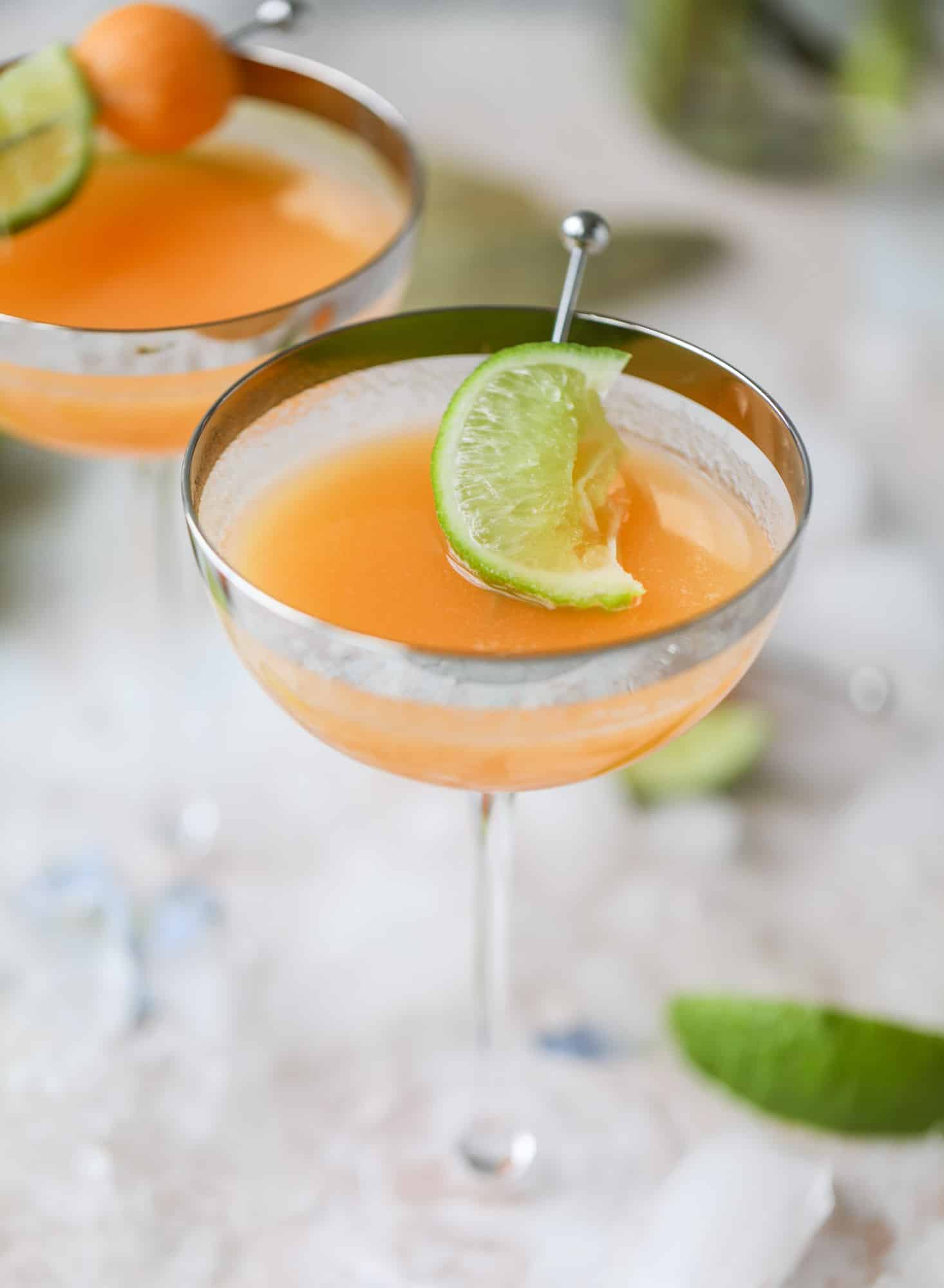 This cantaloupe daiquiri is the perfect way to celebrate summer! Freshly juiced melon, lime juice, rum and maraschino cherries - it's refreshing and cool and a fantastic cocktail to have during happy hour! Isn't the color amazing too?! I howsweeteats.com #cantaloupe #cocktail #daiquiri #lime #rum #summer