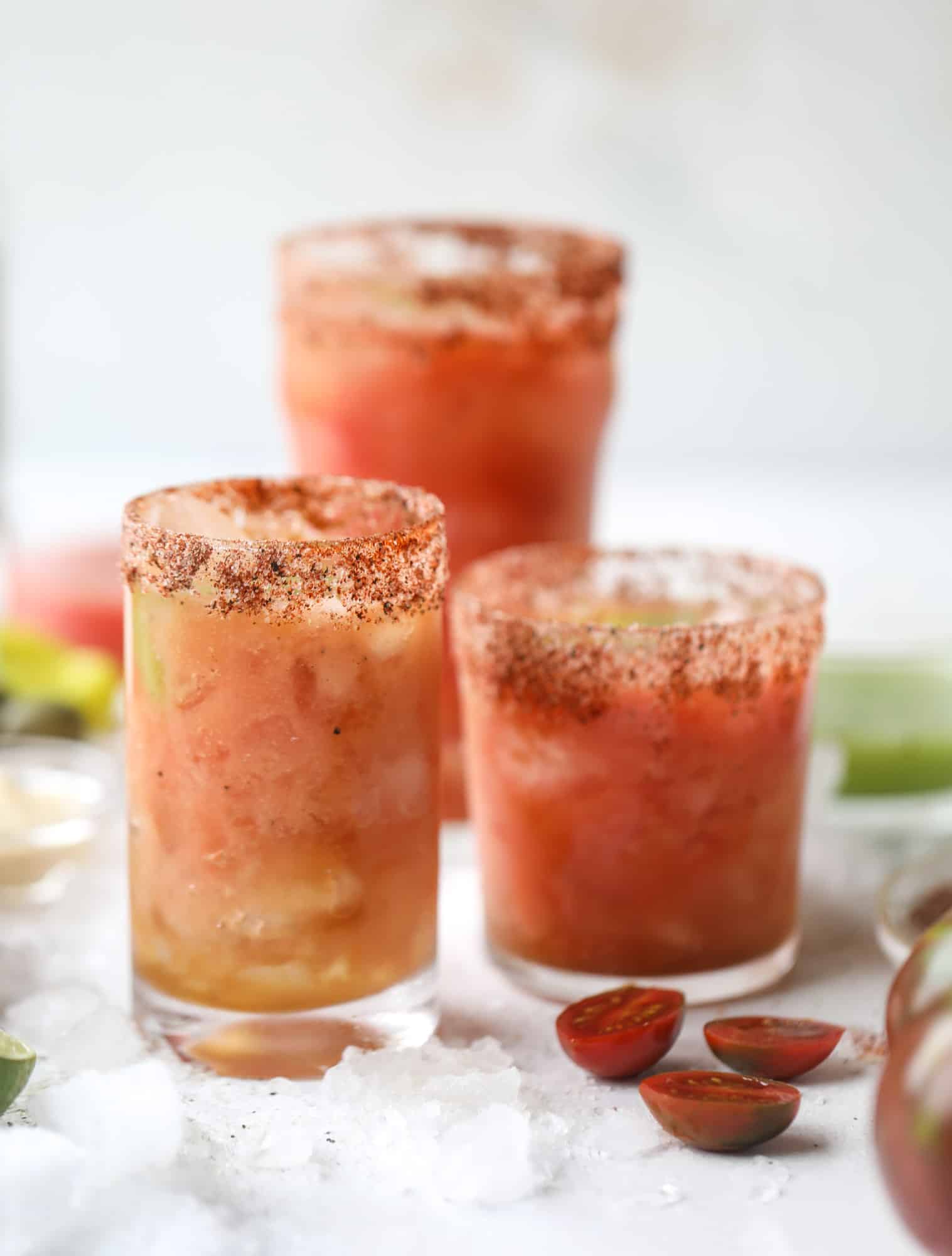 This bloody mary recipe is made with fresh heirloom tomatoes - the gems of summer! The colors swirl together to create a stunning drinking that is loaded with smoky, spicy flavor. Top with your favorite snacks foe the perfect brunch! I howsweeteats.com #bloody #mary #recipe #best #heirloom #tomatoes #cocktail