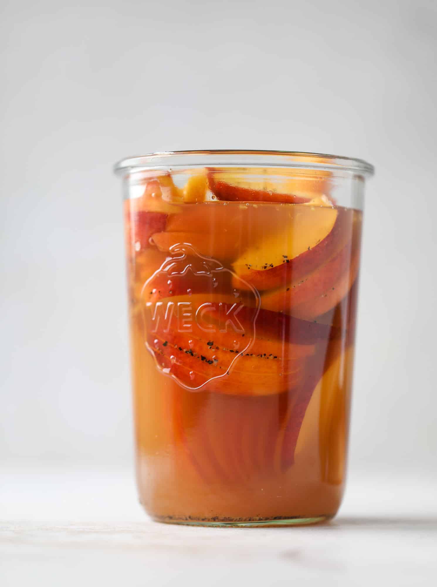 This chipotle pulled pork sandwich is spicy, sweet and saucy. Throw it on a bun or a plate and top it with the most delicious quick pickled peaches and napa cabbage slaw. Flavor and texture make this sandwich incredible! I howsweeteats.com #pulled #pork #chipotle #pickled #peaches #slaw #sandwiches #slow #cooker