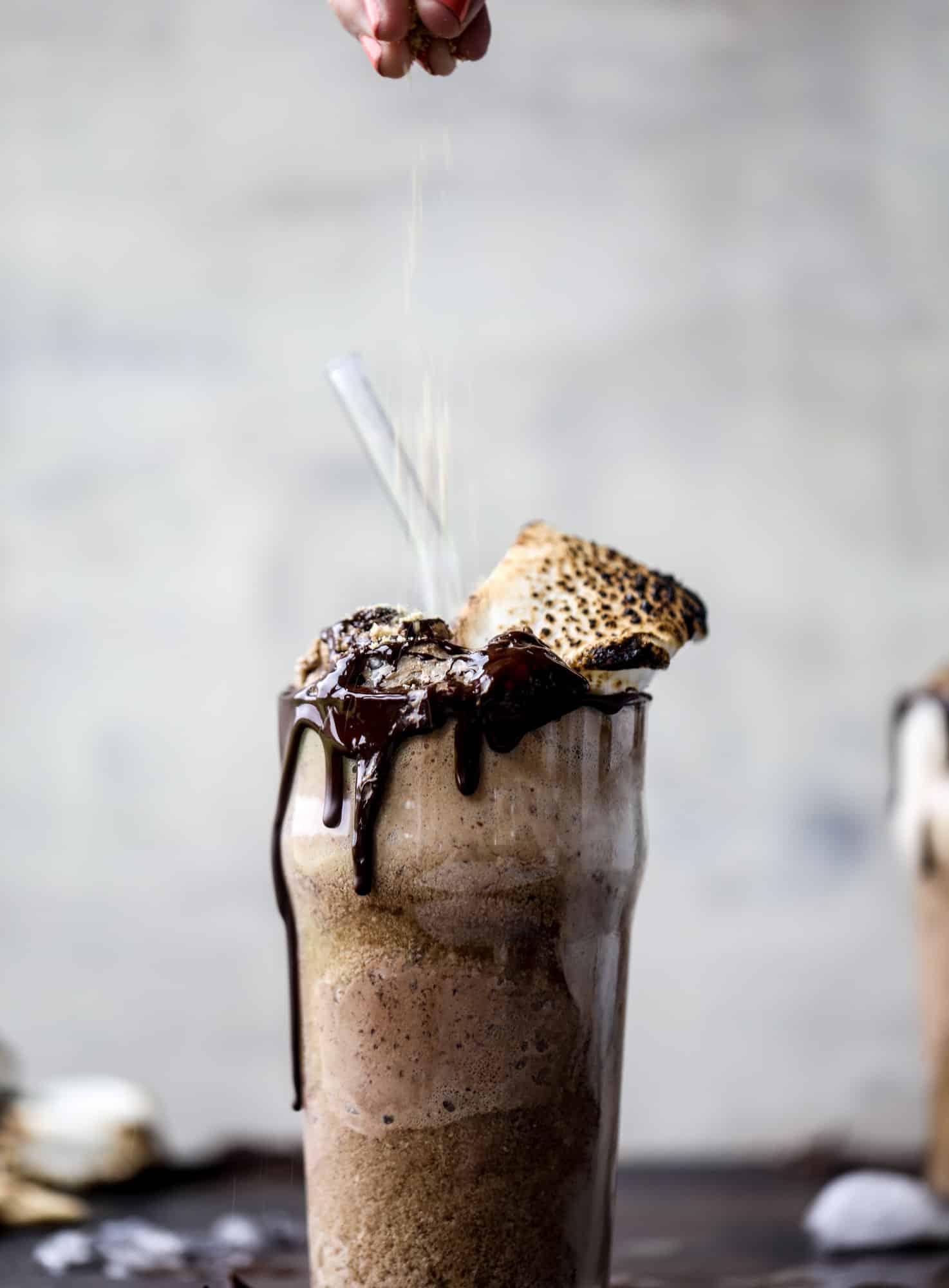 This is the most perfect root beer float, complete with both chocolate and vanilla ice creams. Topped with a smoky s'more, a chocolate fudge rim and a sprinkle of graham cracker crumbs take this super fun drink over the top! I howsweeteats.com #root #beer #float #summer #s'mores #drinks