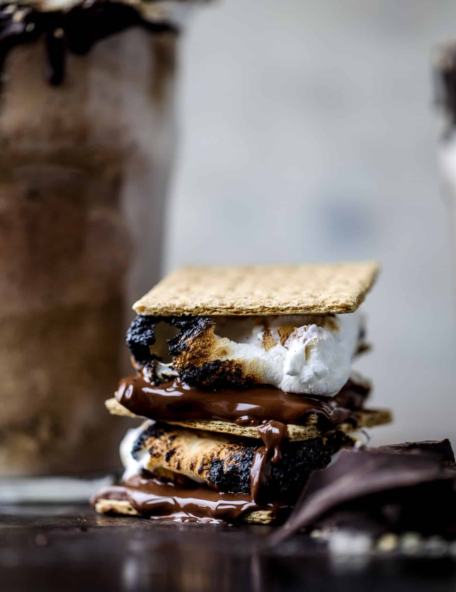 This is the most perfect root beer float, complete with both chocolate and vanilla ice creams. Topped with a smoky s'more, a chocolate fudge rim and a sprinkle of graham cracker crumbs take this super fun drink over the top! I howsweeteats.com #root #beer #float #summer #s'mores #drinks