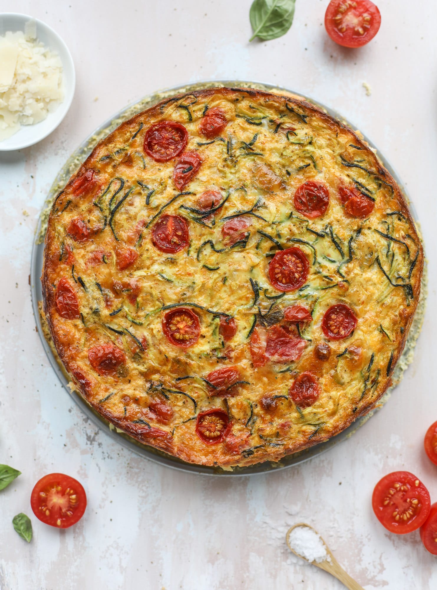 This zucchini pie recipes is absolutely divine and perfect for breakfast or dinner! Completely with garlic and blistered tomatoes, it combines cheese and egg to make a to-die-for frittata-like dish that can be eaten hot or cold! I howsweeteats.com #zucchini #pie #tomatoes #eggs #recipes #garden #summer