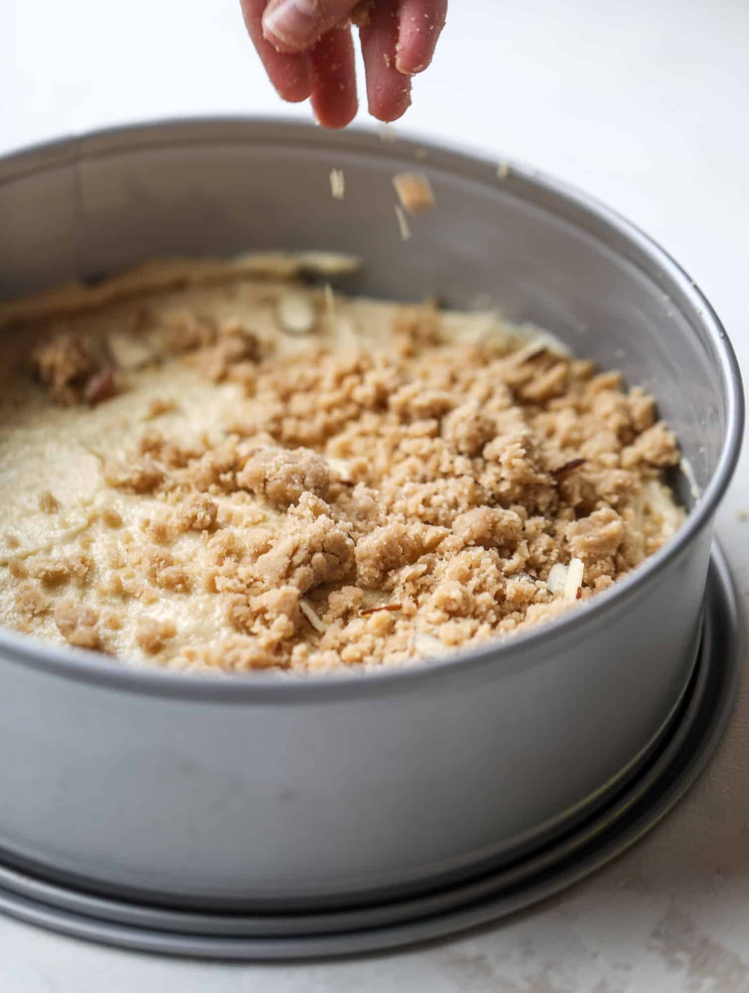 This almond crumb cake is so delicious and perfect for breakfast or dessert! It's full of delicious almond flavor and crunch and the crumb on top is so thick and perfect. It's like an almond croissant on steroids. I howsweeteats.com #almond #crumb #cake