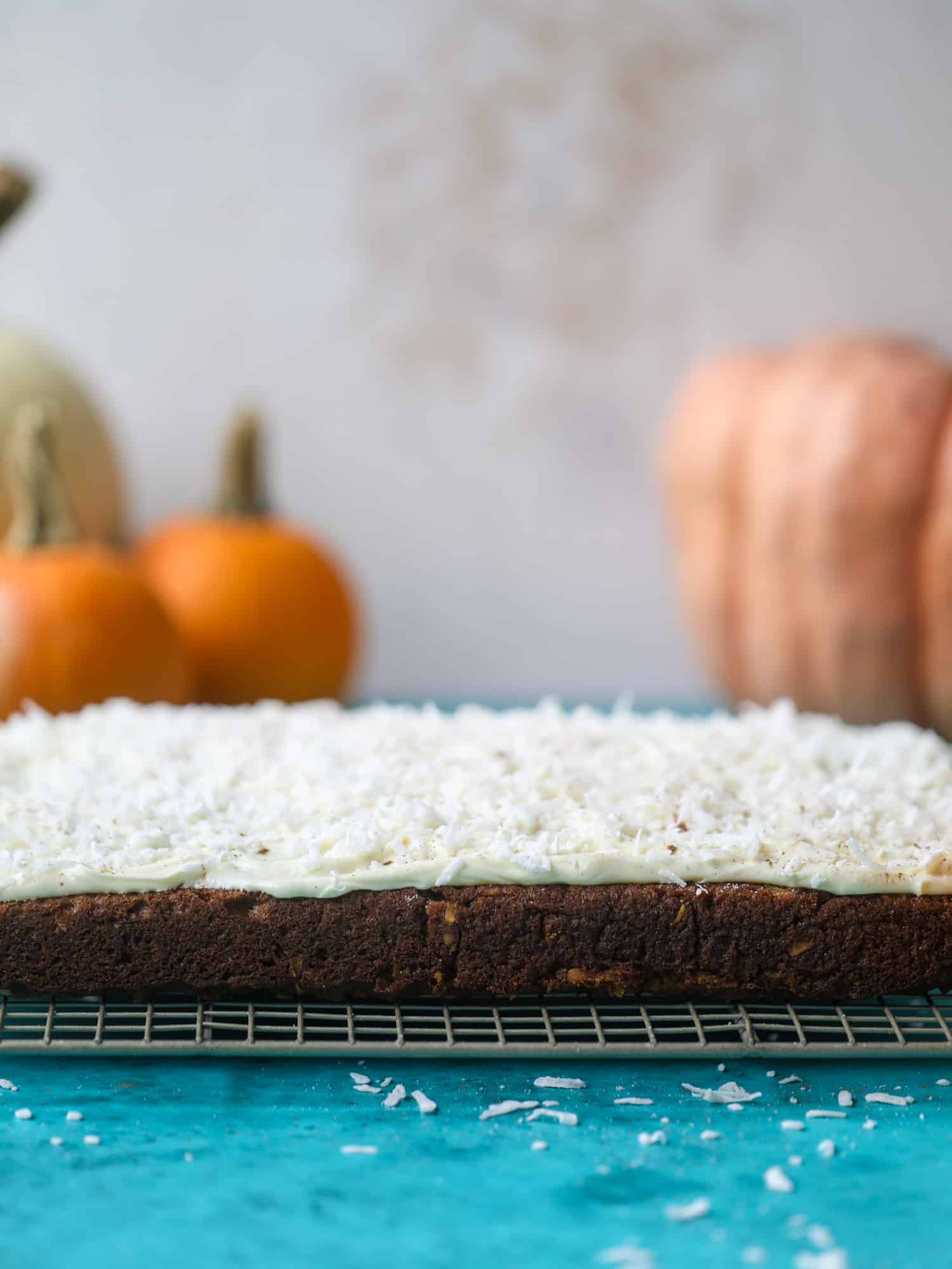 This pumpkin coconut cake is super tender and delicious and comes together quickly in a baking dish! It's spiced for the season and covered in a fluffy coconut cream cheese frosting. You can made it ahead of time for a crowd and it's a huge hit! I howsweeteats.com #pumpkin #cake