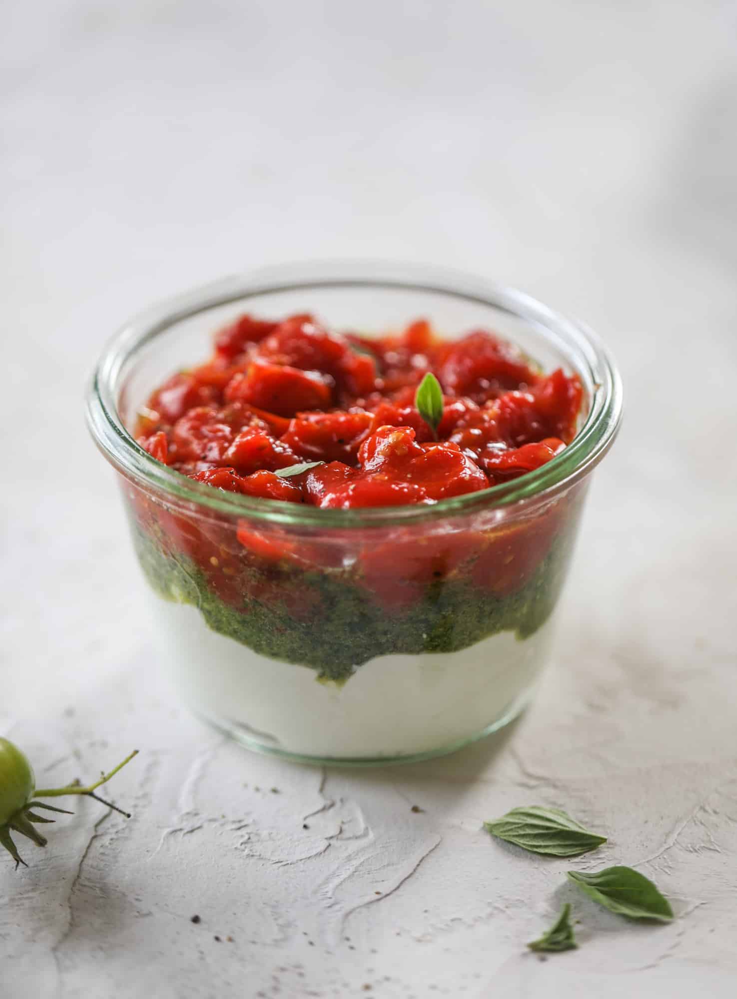 This ricotta jam jar is the perfect appetizer and snack to serve at a party! Based on the ricotta jam jar served at Nordstrom Cafe, it starts with creamy ricotta, is topped with flavorful basil pesto and a quick tomato jam. Serve with crunchy bread and dip dip dip! I howsweeteats.com #ricotta #jam #jar #nordstrom #tomato #pesto #appetizer #dip