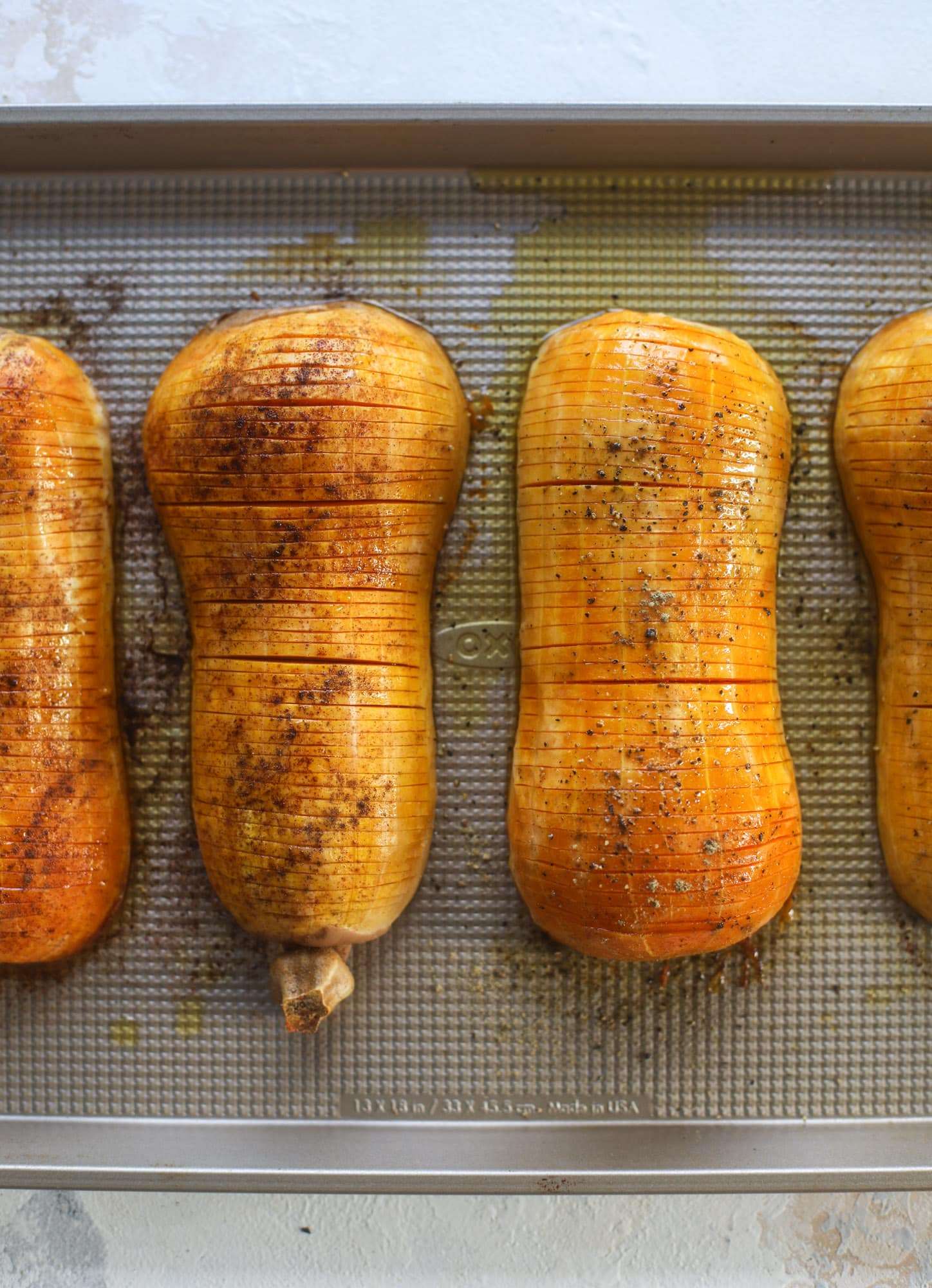This hasselback butternut squash is perfect for Thanksgiving - and you can easily make it two ways! We have a maple pecan hassleback butternut squash and a brown butter sage hasselback butternut squash. Delicious! I howsweeteats.com #hasselback #butternutsquash
