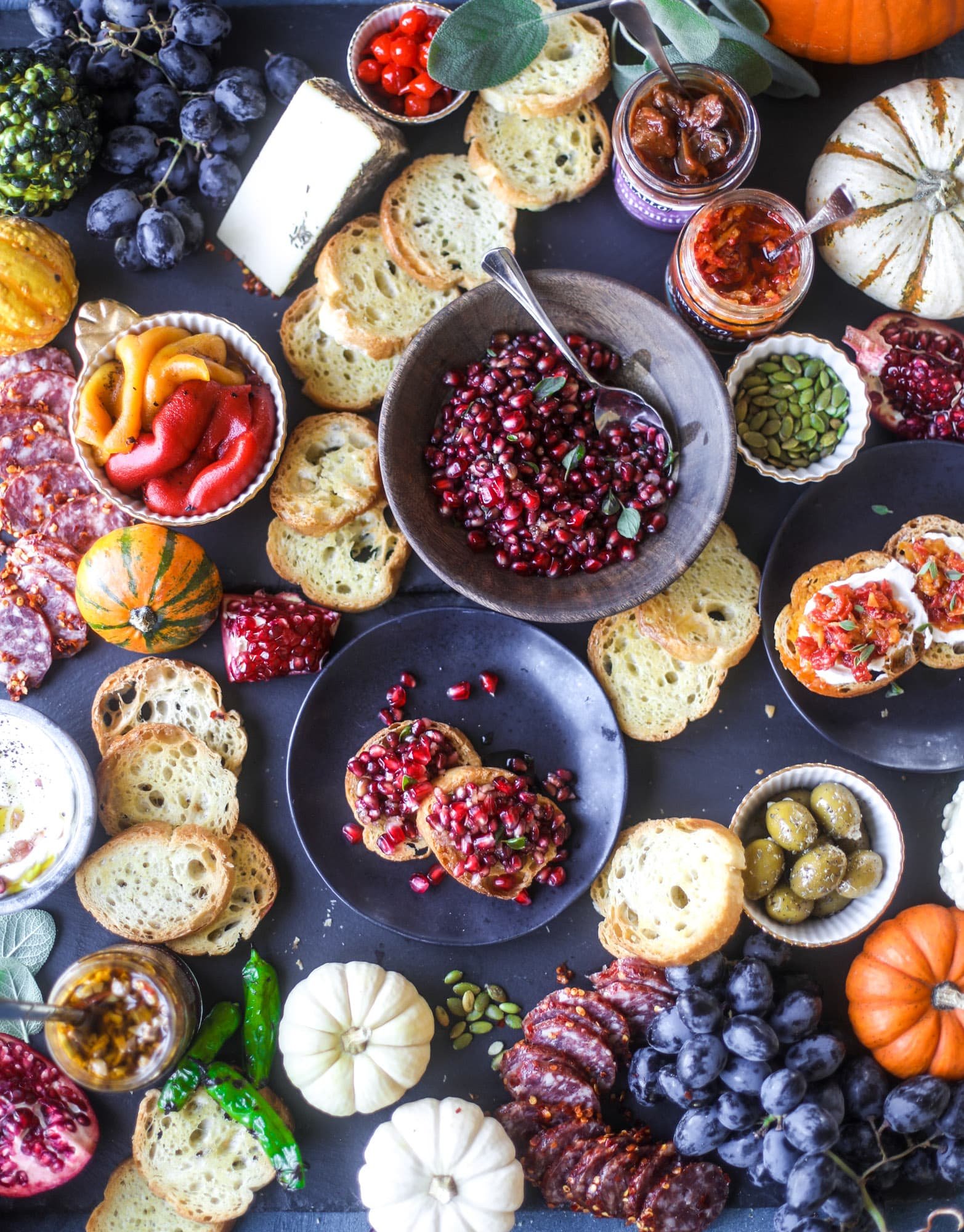 This is the perfect autumn harvest bruschetta board to feed a crowd or serve at a party! The standout is pomegranate relish with a cinnamon shallot vinaigrette, lots of toasty bread, bruschettas, cheese and olives. Everything that's delish! I howsweeteats.com #bruschetta #board