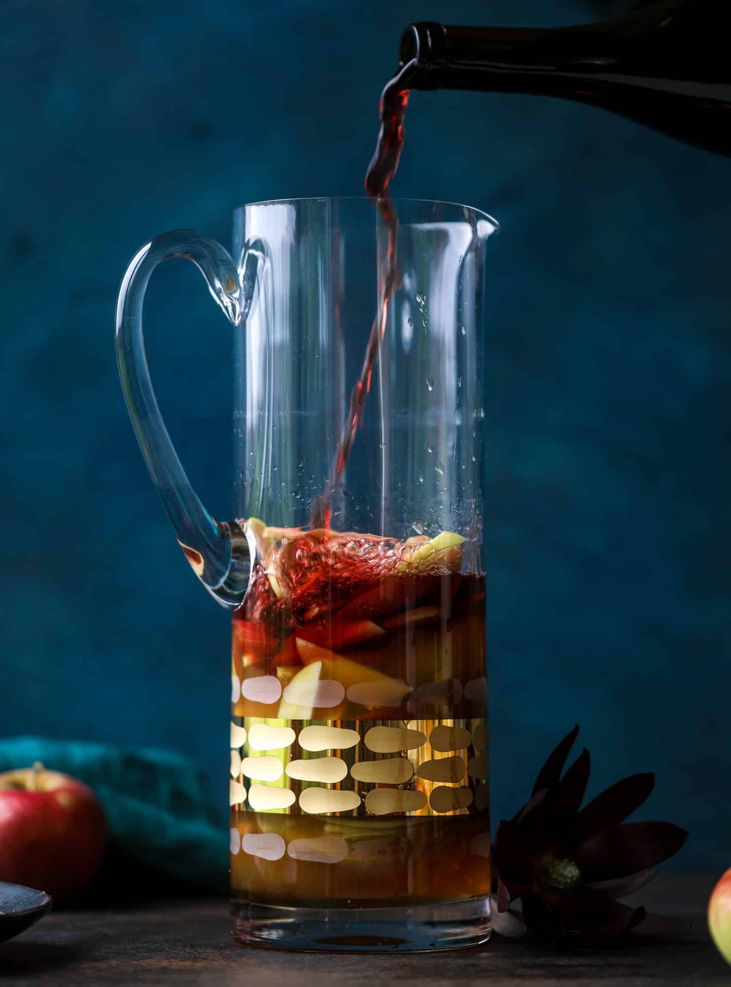 This red apple cider sangria will soon because a staple for your fall! It's delicious and not too sweet, with a base of red wine, apple cider and maple syrup. Cinnamon sticks and apple slices round out the pitcher and it's so flavorful and perfect for the season! I howsweeteats.com #red #apple #cider #sangria 
