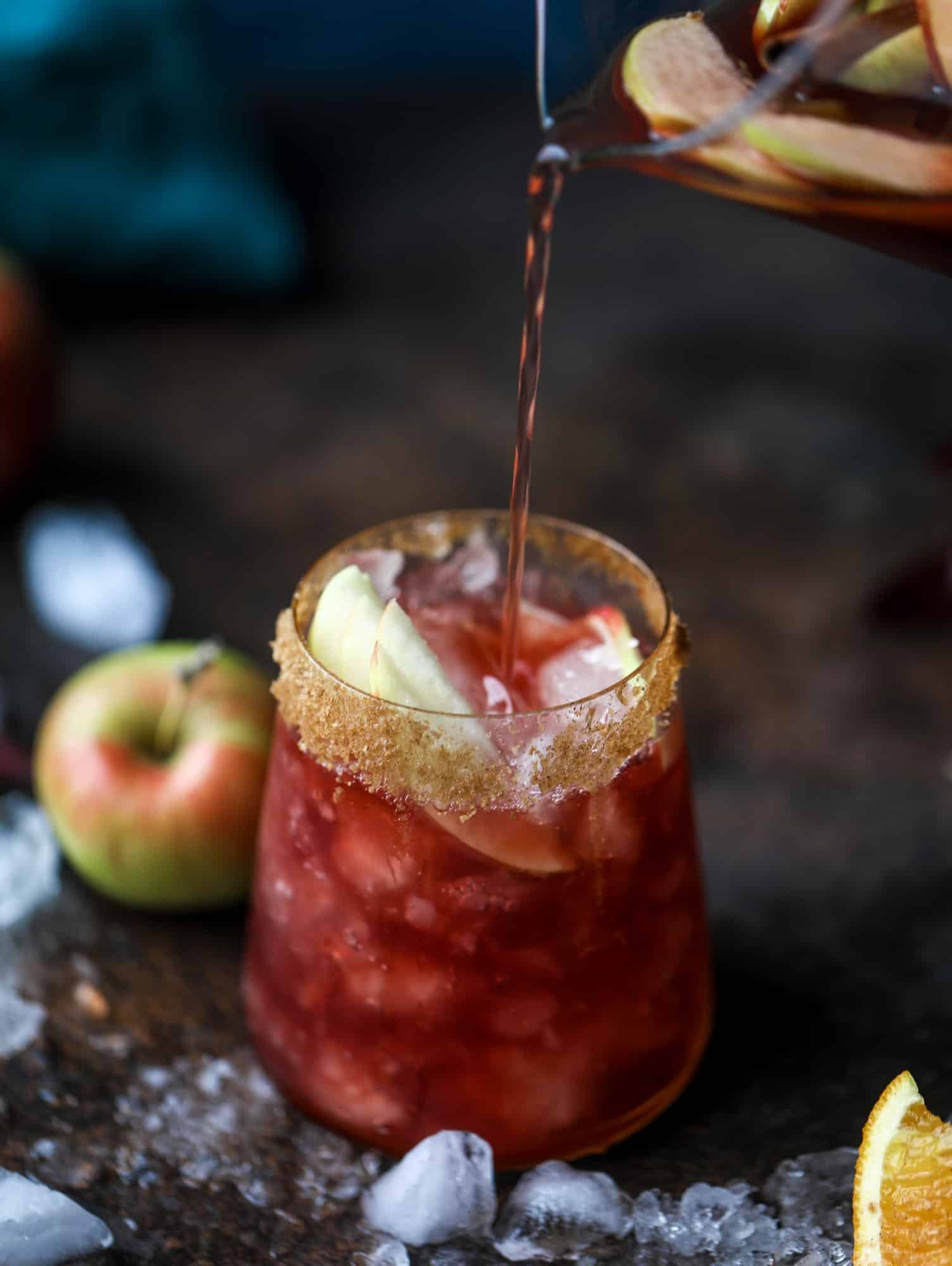 This red apple cider sangria will soon because a staple for your fall! It's delicious and not too sweet, with a base of red wine, apple cider and maple syrup. Cinnamon sticks and apple slices round out the pitcher and it's so flavorful and perfect for the season! I howsweeteats.com #red #apple #cider #sangria 
