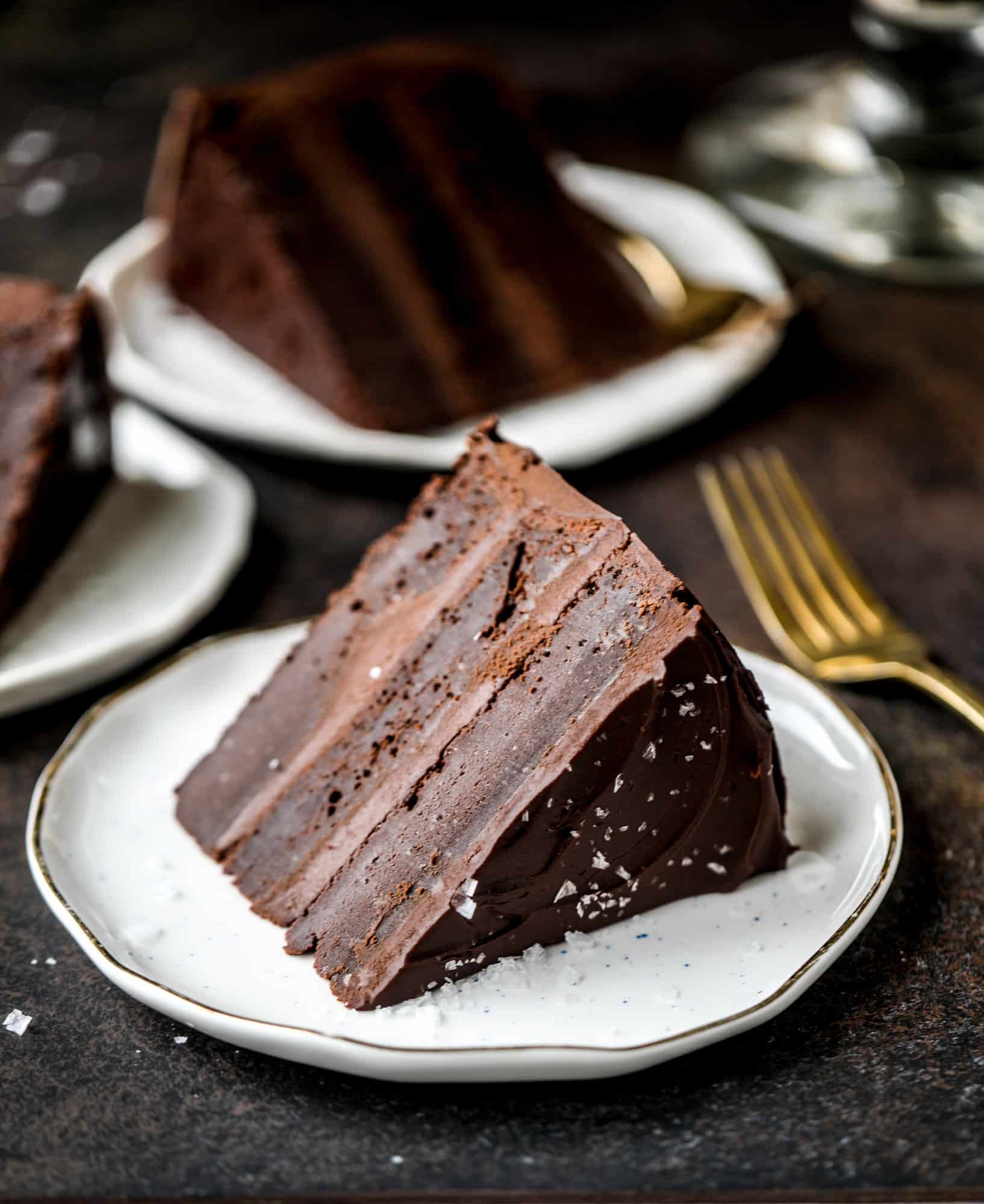 This salted dark chocolate stout cake is absolutely divine! It's ridiculously rich and perfect for a crowd or a party. Pumpkin stout batter is baked into fluffy laters and covered in a super fudgy chocolate ganache. Perfect for chocolate lovers! I howsweeteats.com #dark #chocolate #stout #cake #salted