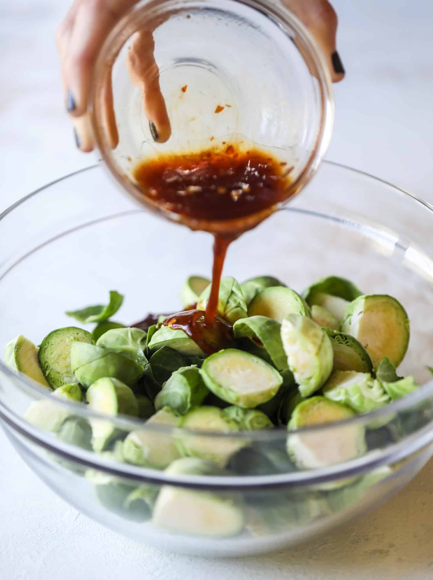 These sweet and spicy brussels sprouts are roasted to perfect and the most delicious side dish! It's a great way to elevate regular old brussels sprouts and make a fantastic side to to serve on a weeknight! I howsweeteats.com #spicy #brusselssprouts