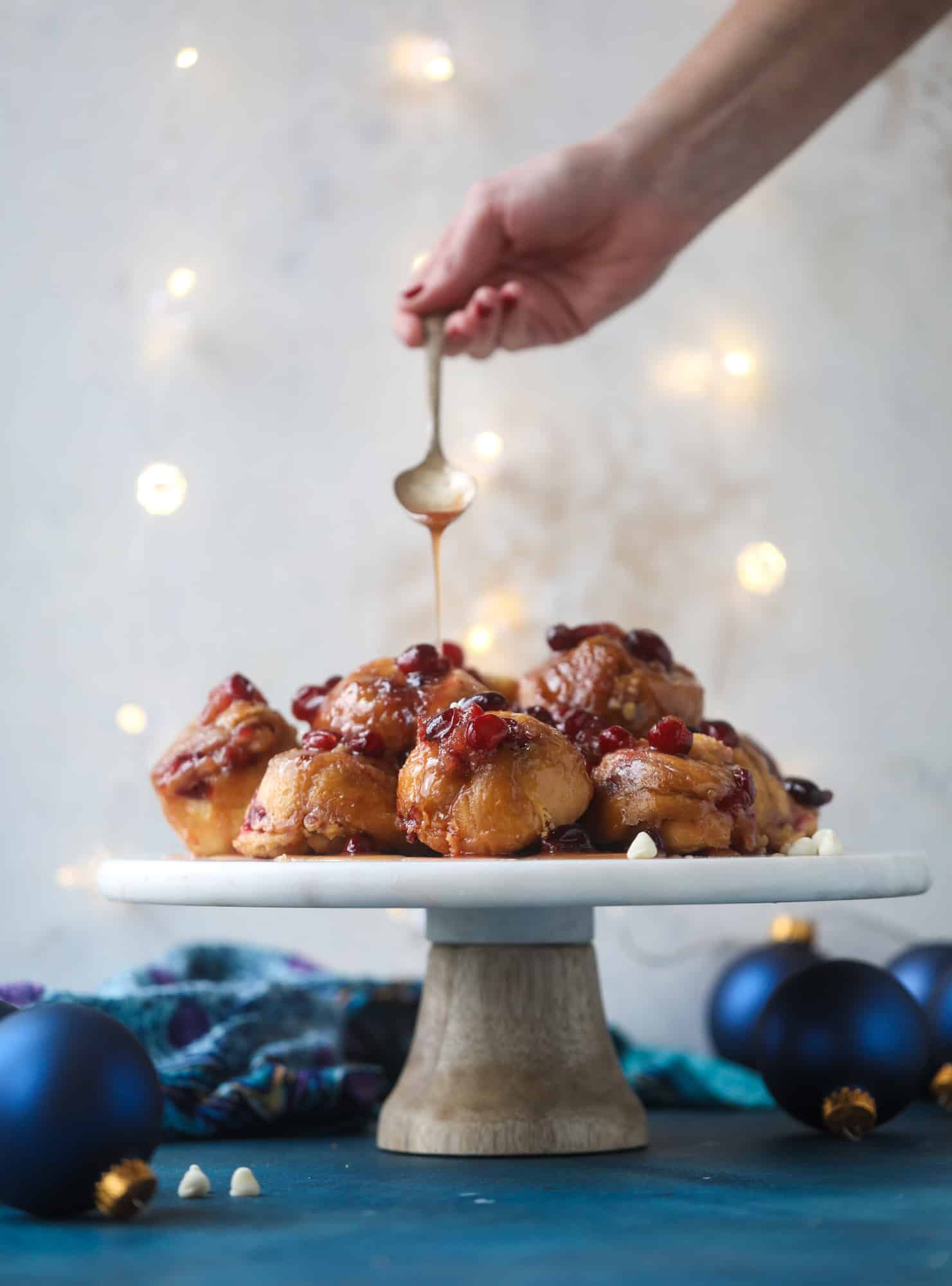 These white chocolate cranberry sticky buns are what holiday dreams are made of! Made in a muffin tin with fresh cranberries and creamy white chocolate, they are drizzled with cranberry caramel too! Dreamy! I howsweeteats.com #sticky #buns