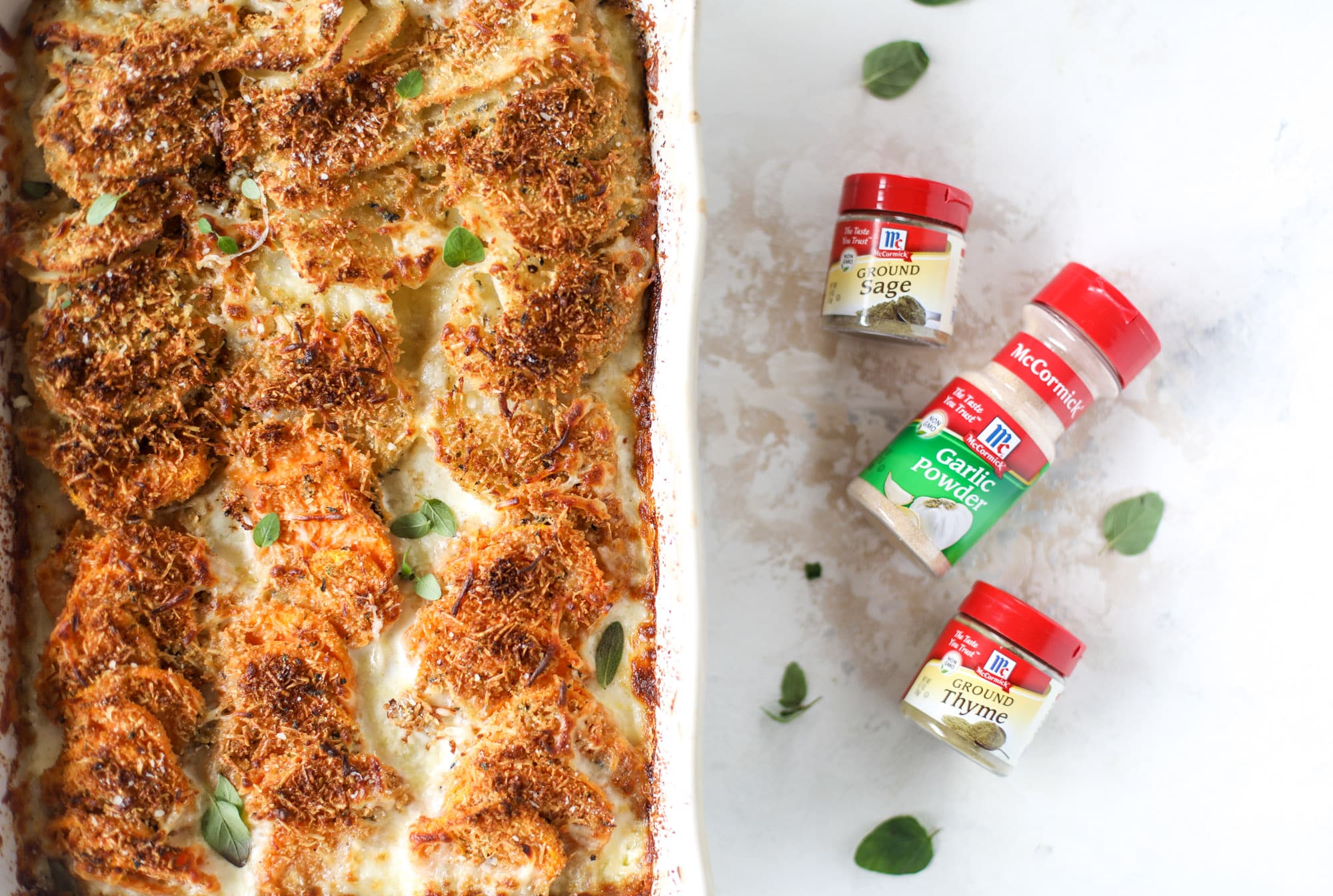 These scalloped potatoes are a cheese lover's dream. Sharp asiago and cream envelops idaho and sweet potatoes in these scalloped potatoes to please everyone! The crunchy asiago topping is irresistible. I howsweeteats.com #scalloped #potatoes