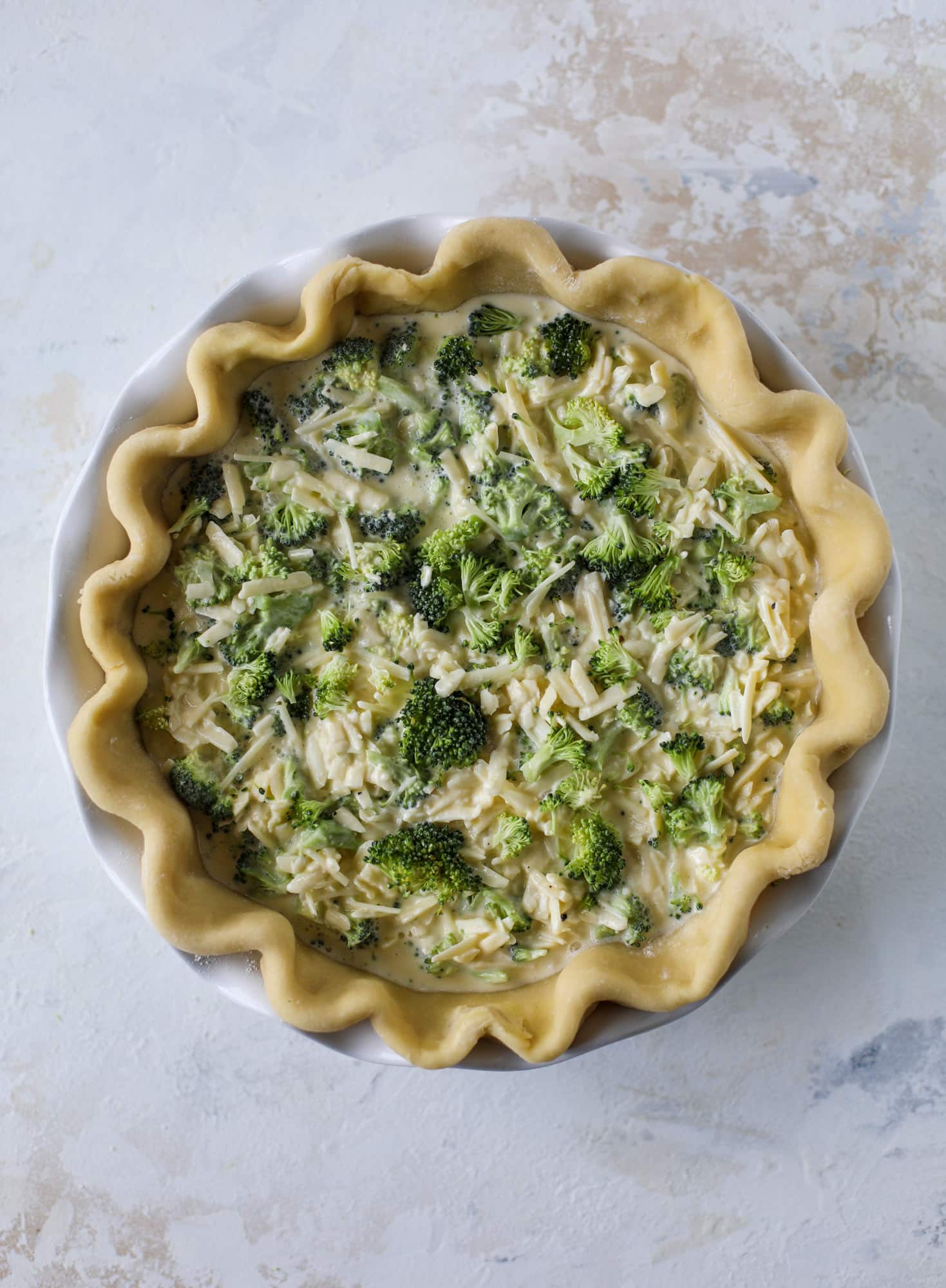 This broccoli cheese quiche is absolutely perfect for brunch, lunch or even dinner! It's delicious served warm or cold, perfect paired with a greens salad and is a recipe that can be made ahead of time! I howsweeteats.com #broccolicheese #quiche