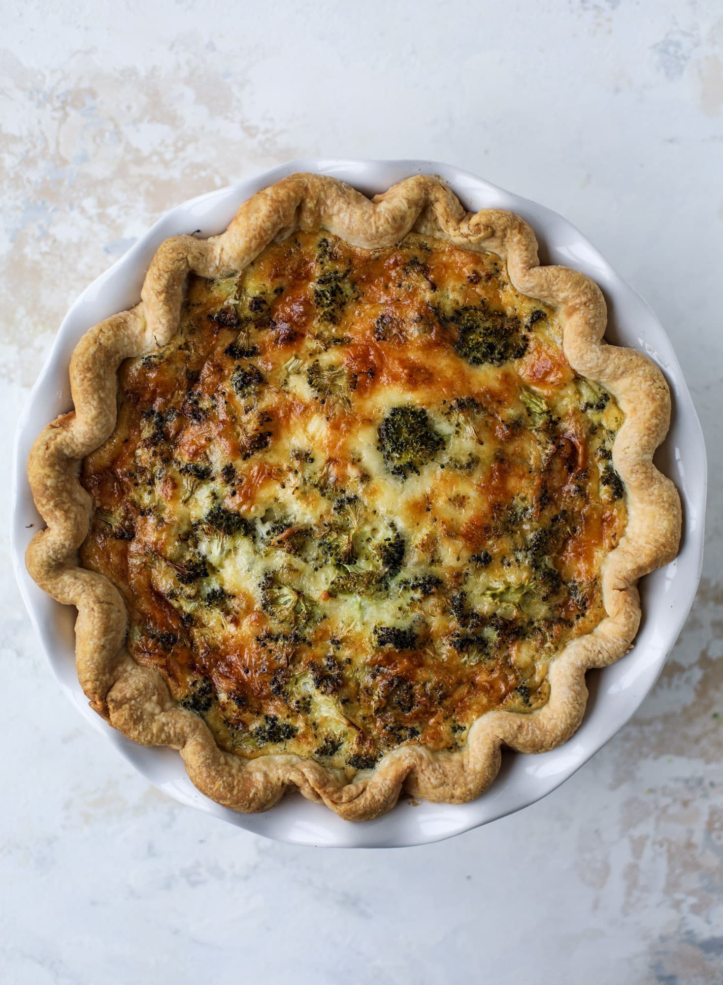 This broccoli cheese quiche is absolutely perfect for brunch, lunch or even dinner! It's delicious served warm or cold, perfect paired with a greens salad and is a recipe that can be made ahead of time! I howsweeteats.com #broccolicheese #quiche
