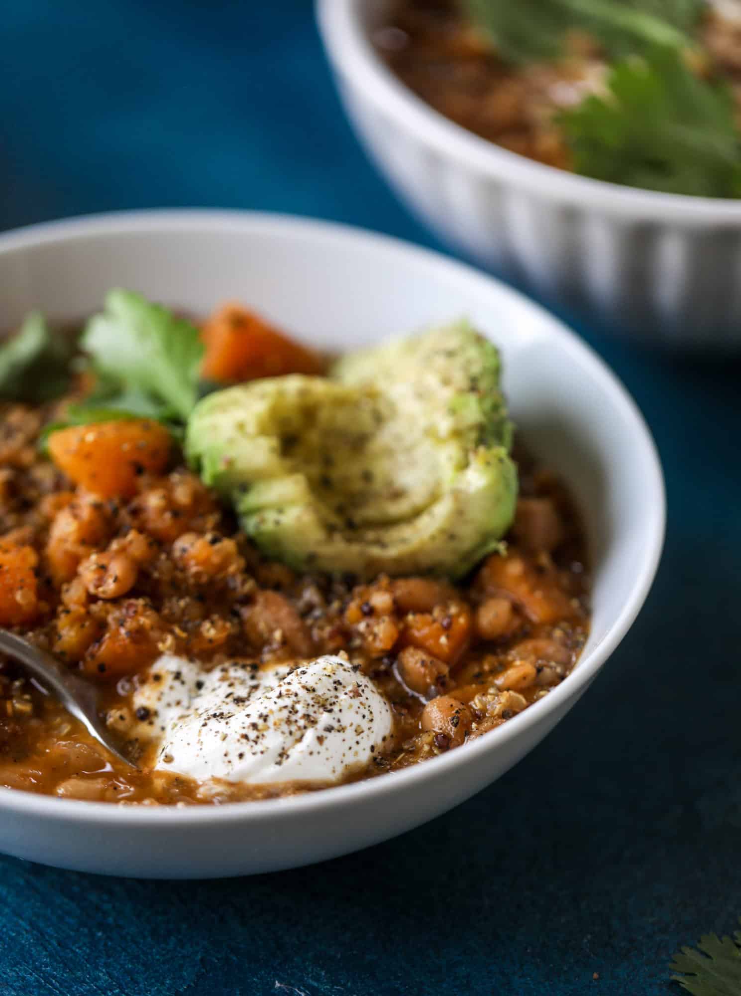 This butternut squash chili is super satisfying and delicious! It's made with pinto beans and quinoa, comes together quickly and is filling and perfect to reheat for lunches. Everything you want in a vegetarian chili! I howsweeteats.com #butternutsquash #chili