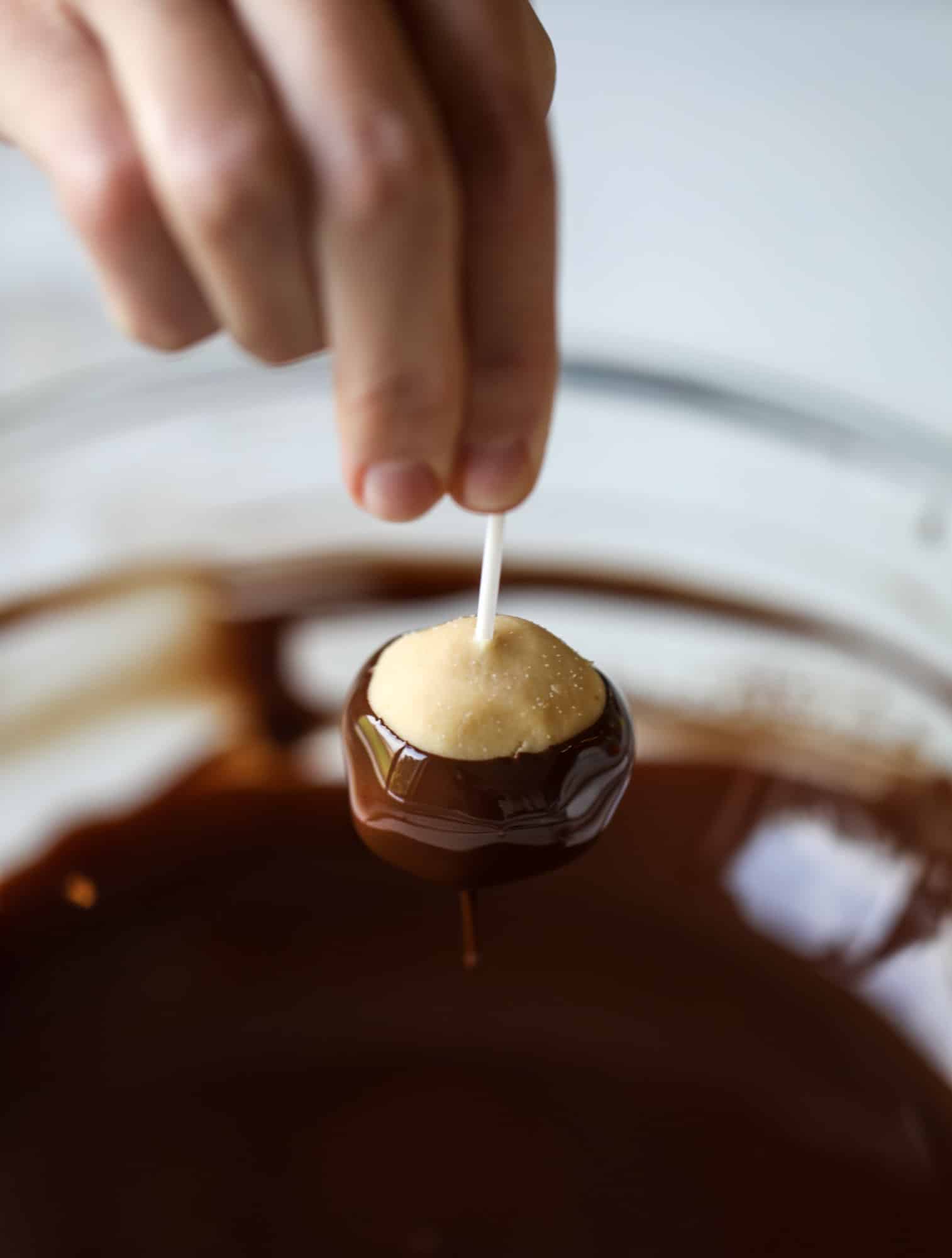 These cashew butter buckeyes are a fun and modern twist on the traditional buckeye recipe! Creamy cashew butter makes a delicious, rich dough and then it's coated in chocolate and sprinkled with sea salt. Delicious! I howsweeteats.com #cashewbutter #buckeyes