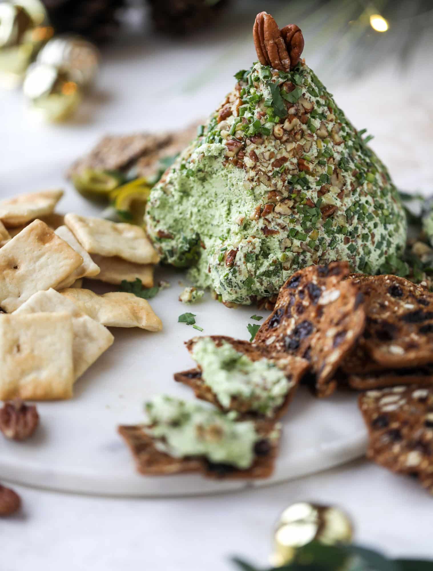 This green goddess cheese ball is the perfect party snack! You can make it ahead of time and shape it into a cute tree for a festive look. Serve it with crispy crackers and pita chips! I howsweeteats.com #greengoddess #cheeseball