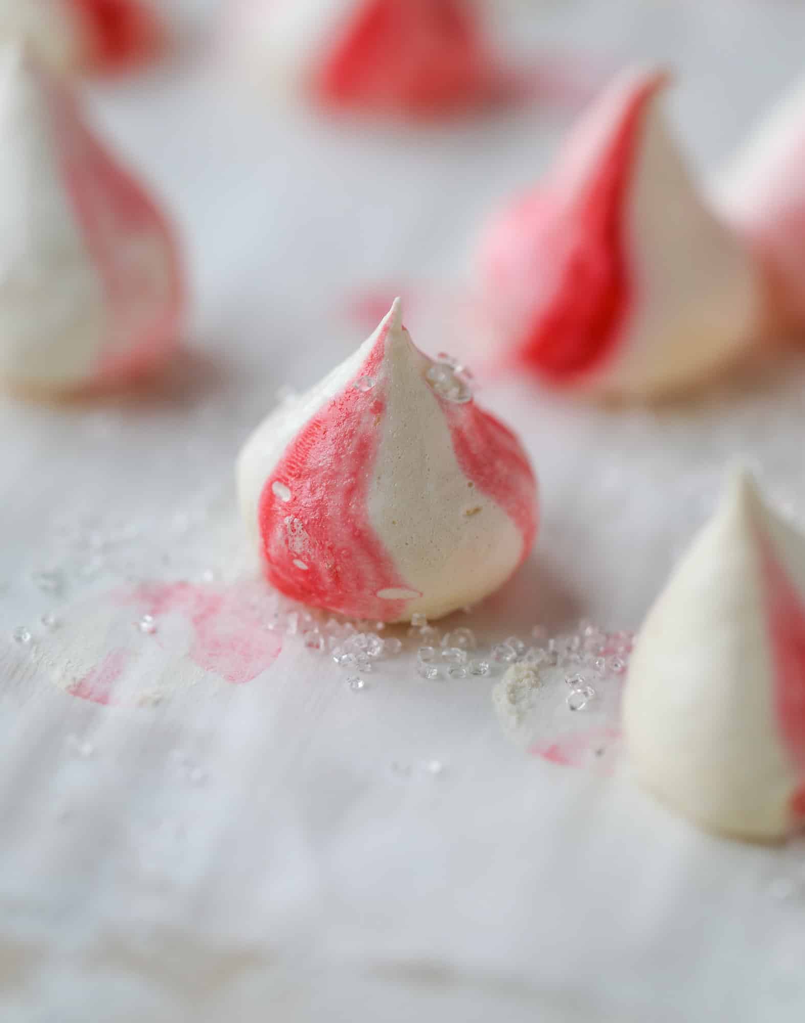 This pink peppermint cake is festive and delicious for the holidays! Layers of vanilla cake frosting with peppermint cream cheese frosting, covered in sparkly sugar and peppermint meringues. Couldn't be cuter! I #pinkpeppermint #cake