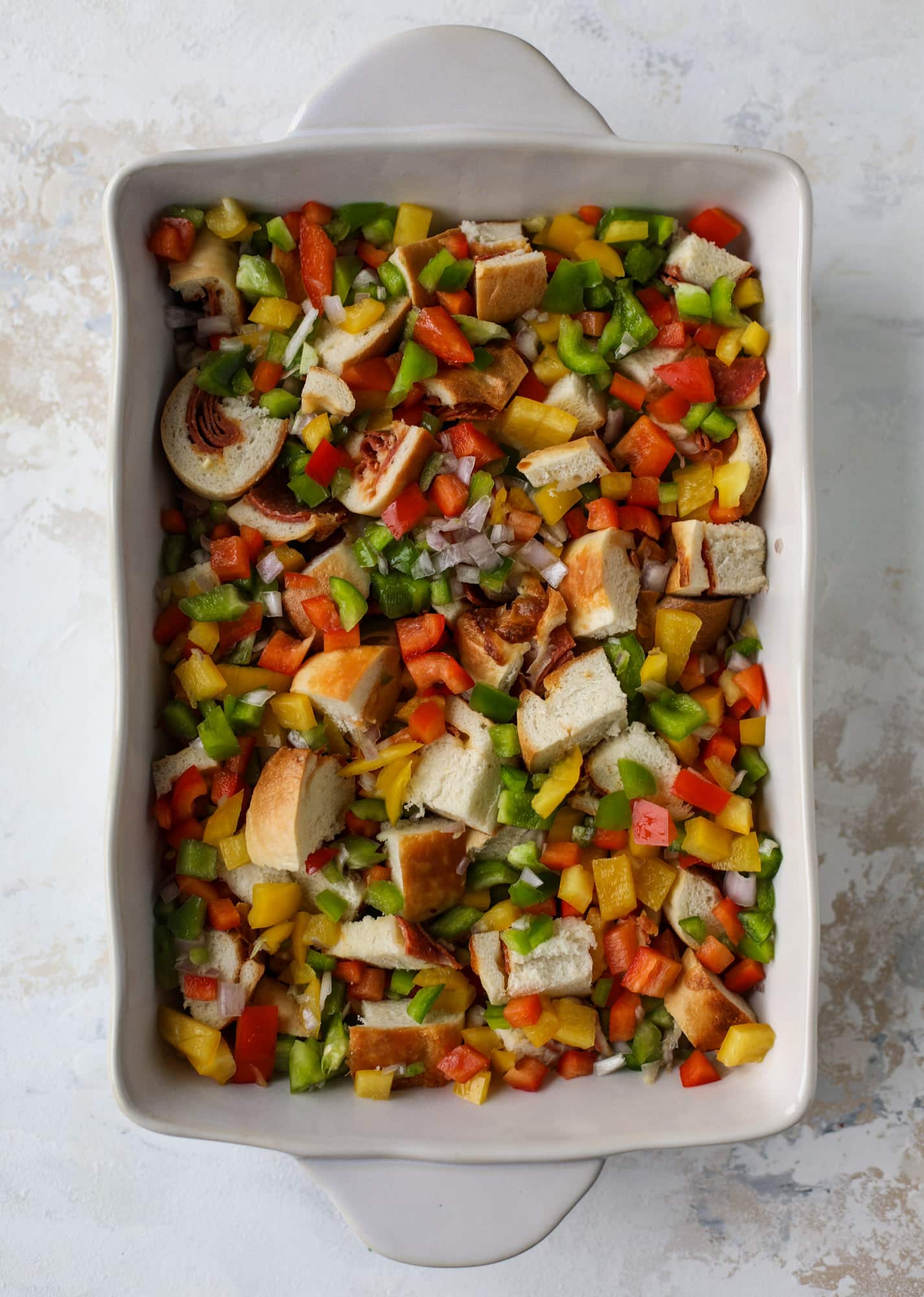 This breakfast strata is super special because the base is built on pepperoni rolls! This make ahead casserole is perfect for holiday brunches or parties and tastes like a supreme pizza. It's so easy to throw together too! I howsweeteats.com #breakfast #strata