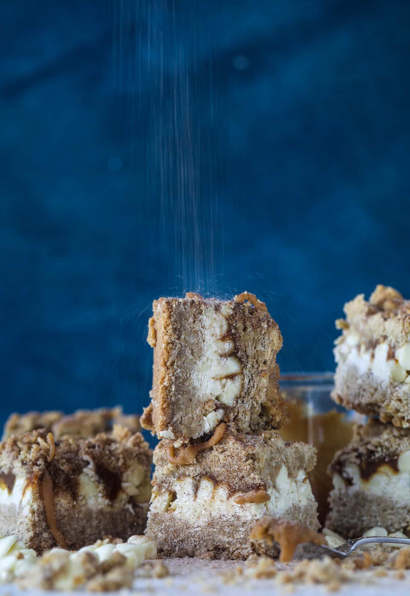 These snickerdoodle caramelitas have a layer of chewy, cinnamon sugared oatmeal bar topped with cream white chocolate and more crumbly, chewy oatmeal bites. They are super delicious and festive! I howsweeteats.com #snickerdoodle #caramelitas